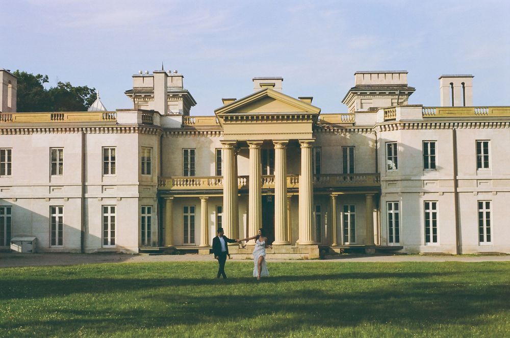 Classic architecture of a grand historic mansion with columns and expansive grounds.