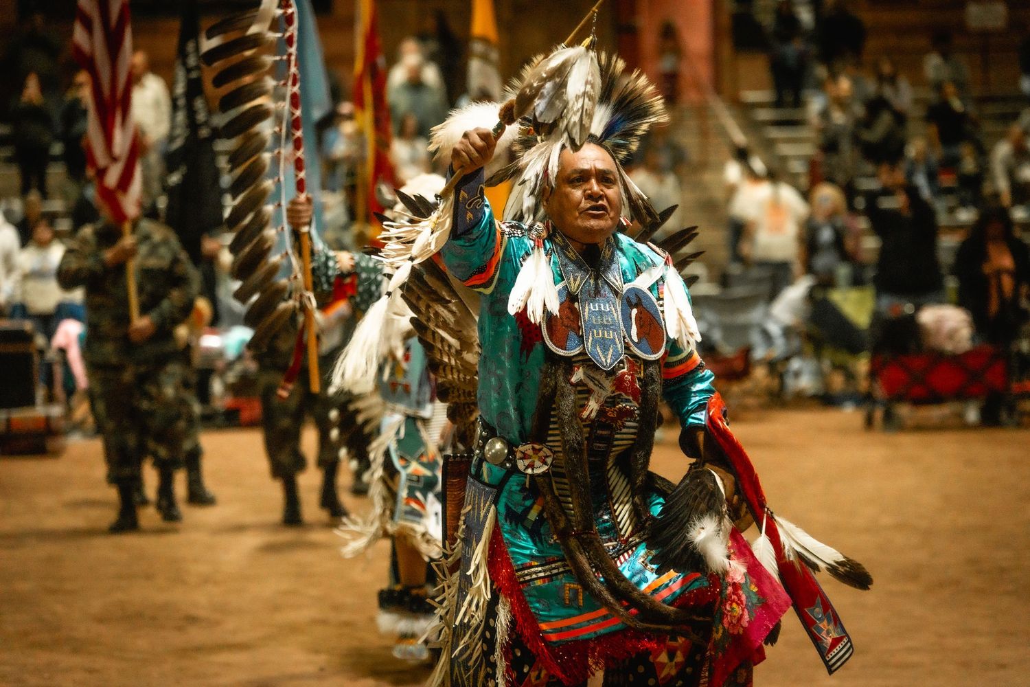 Colorful traditional Native American dancers performing at a powwow ceremony.