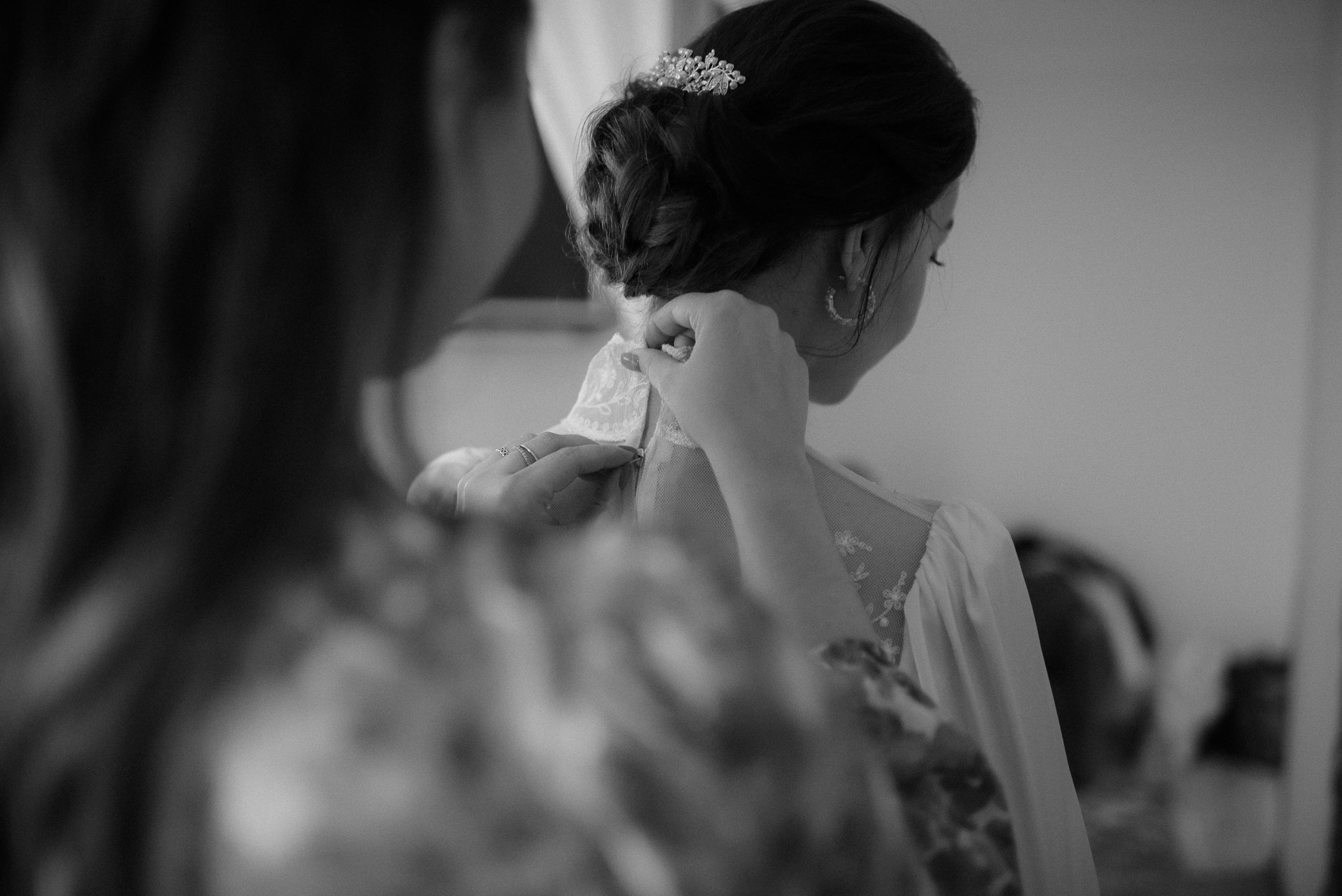 Elegant wedding preparation scene showing delicate lace details in black and white photography.