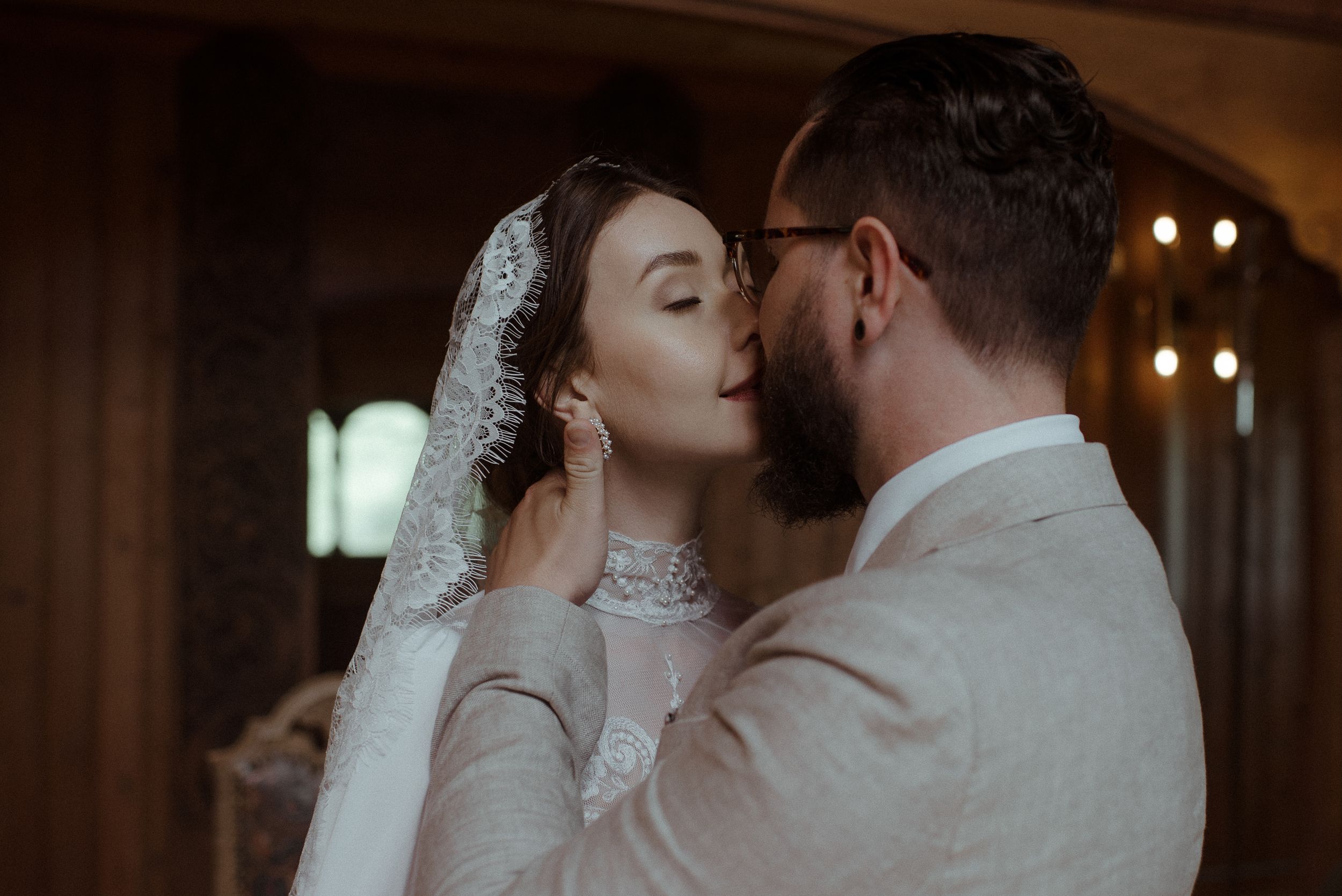 An intimate wedding moment captured in warm tones as the couple shares a tender moment in their formal attire.