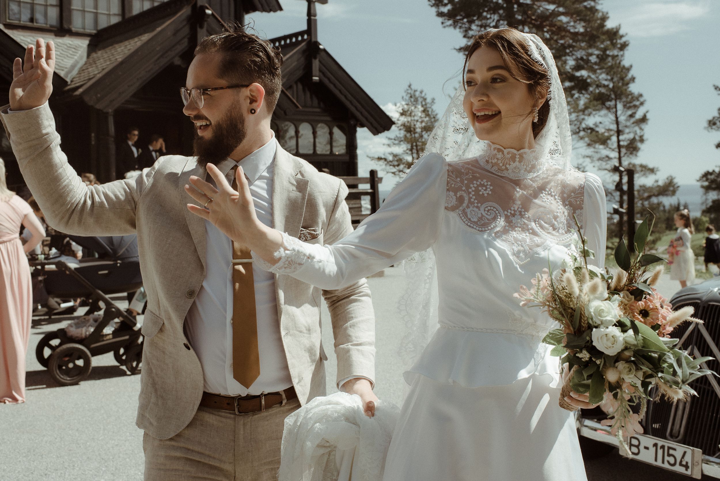 A joyful wedding couple dancing together outside a rustic wooden building on their special day.