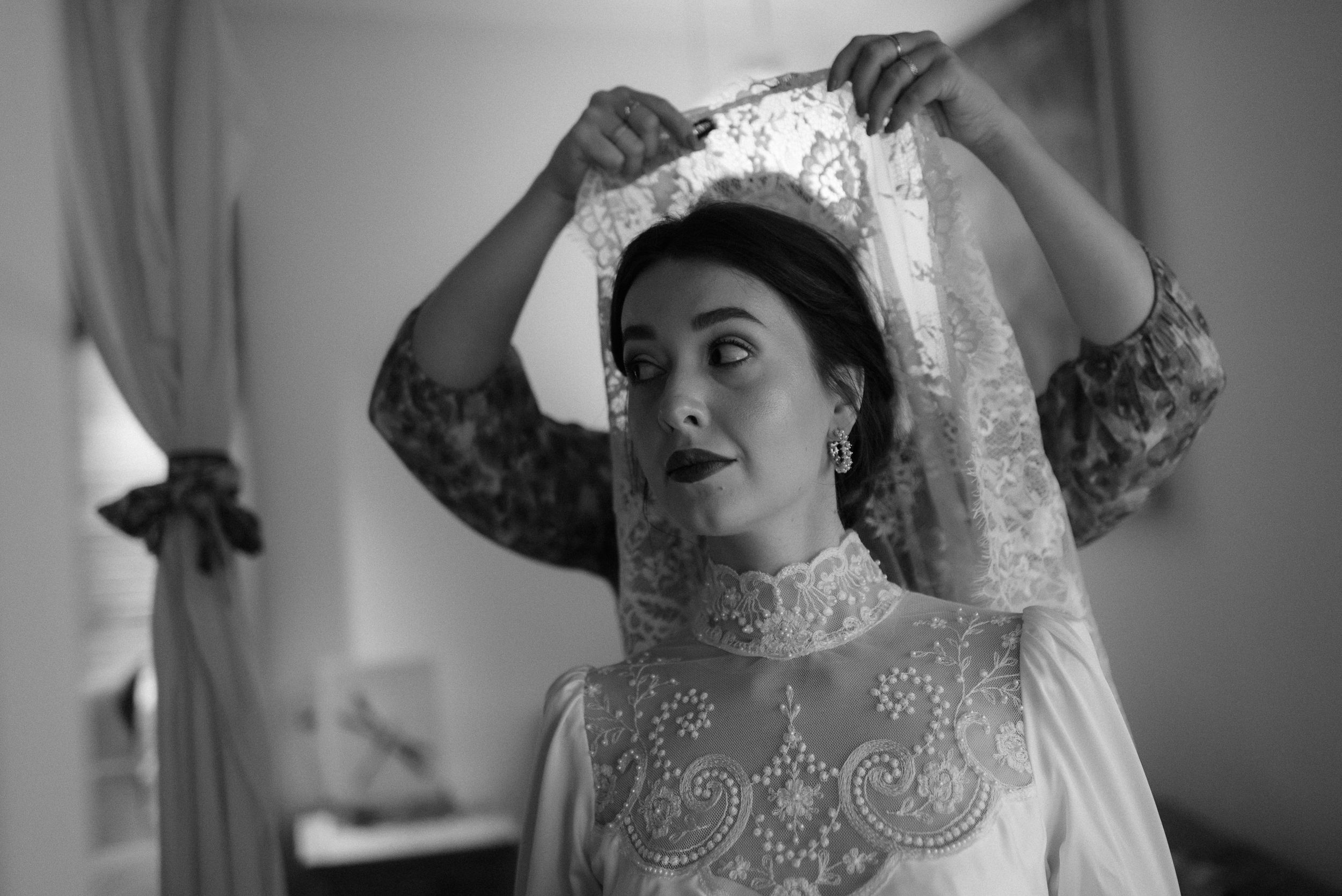 Classic bridal portrait showing intricate lace details of wedding dress in black and white.