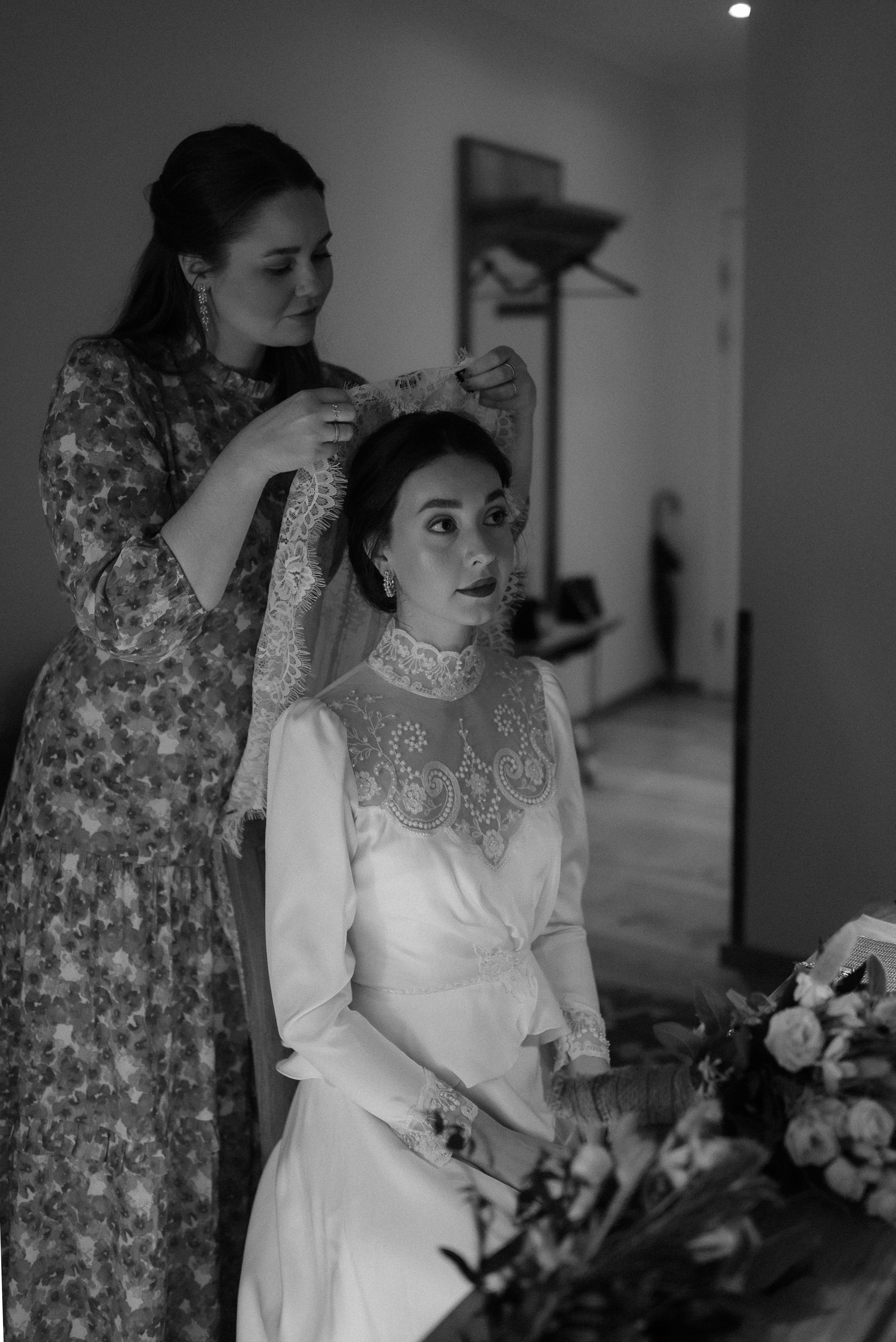 Wedding preparation scene with detailed lace dress and floral arrangements.