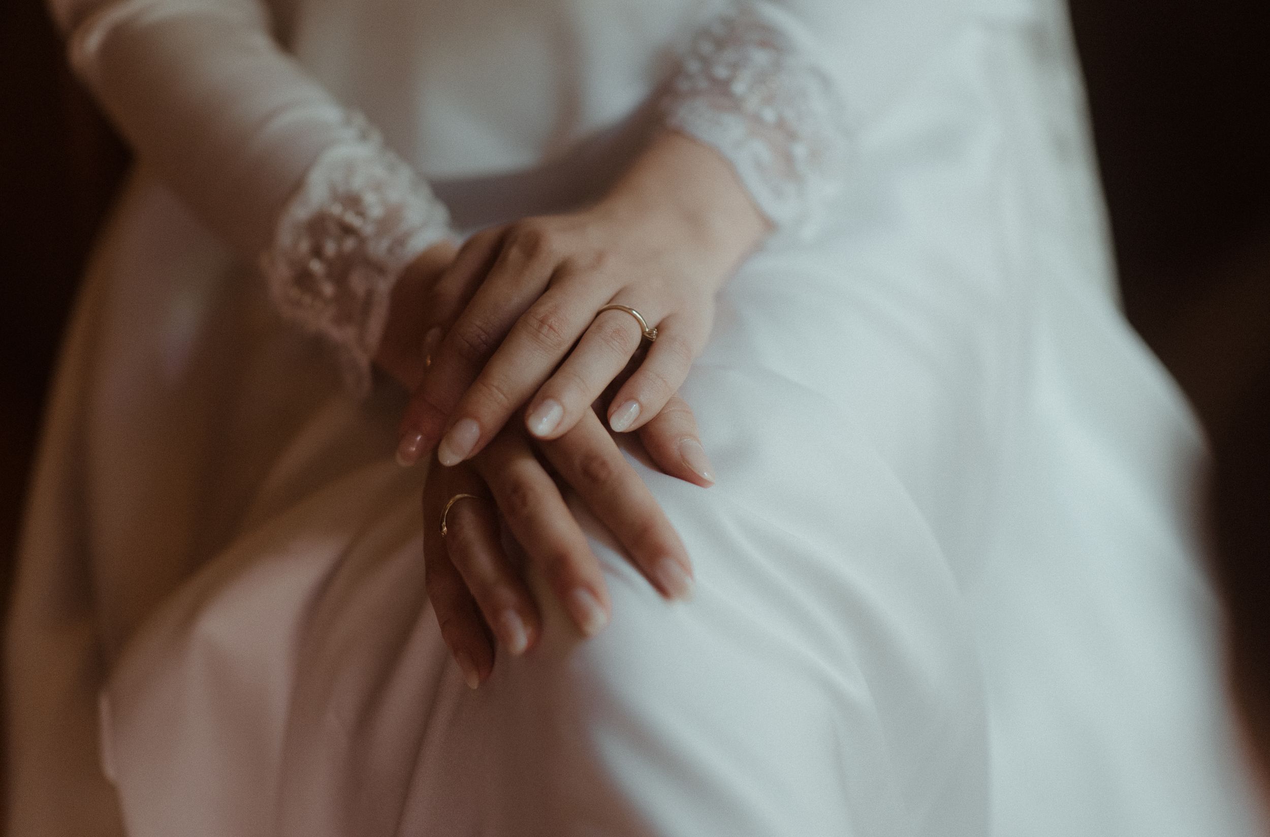 Close-up of lace sleeve detail on elegant white wedding dress.