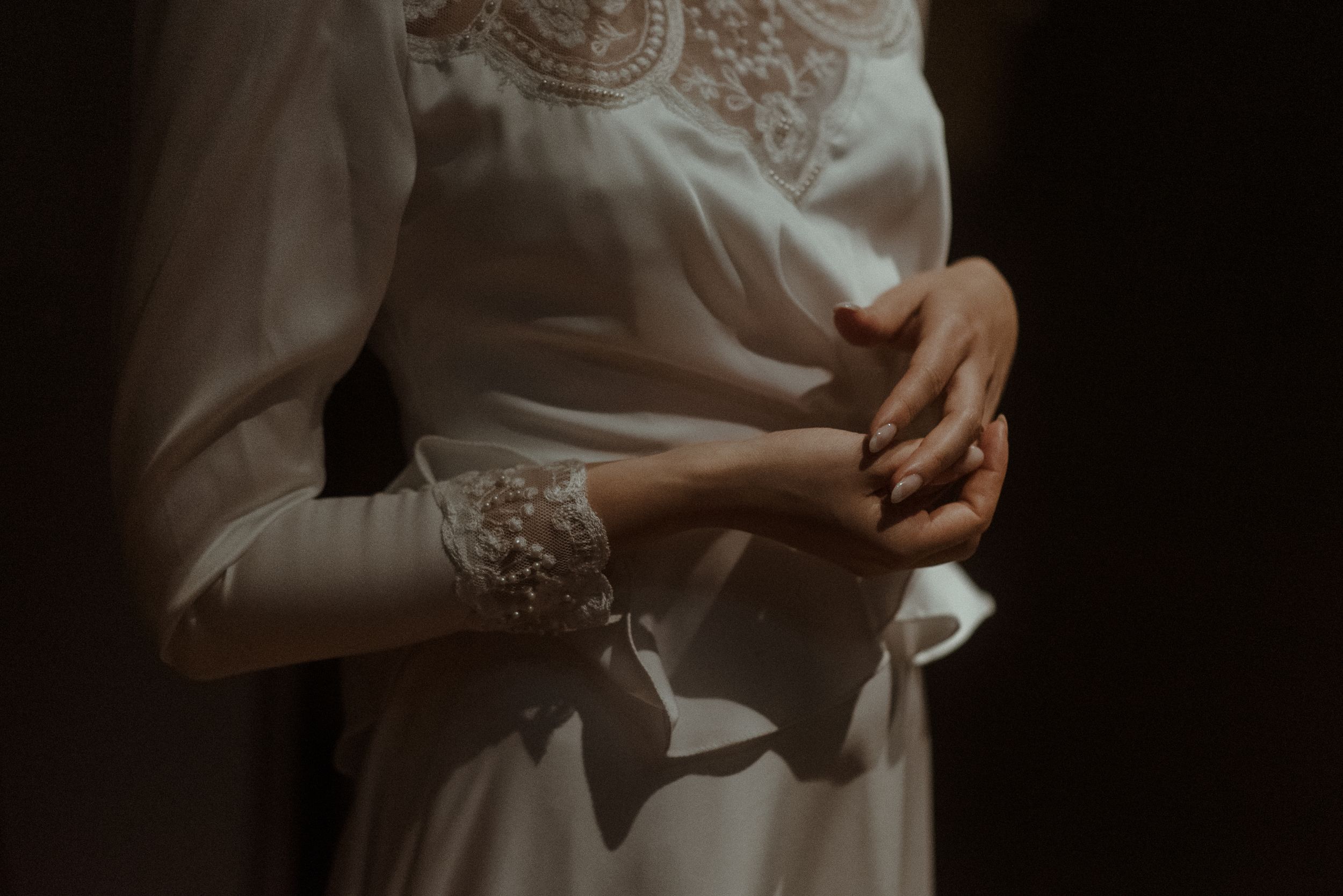 Close up detail shot of delicate lace sleeves on a wedding dress.