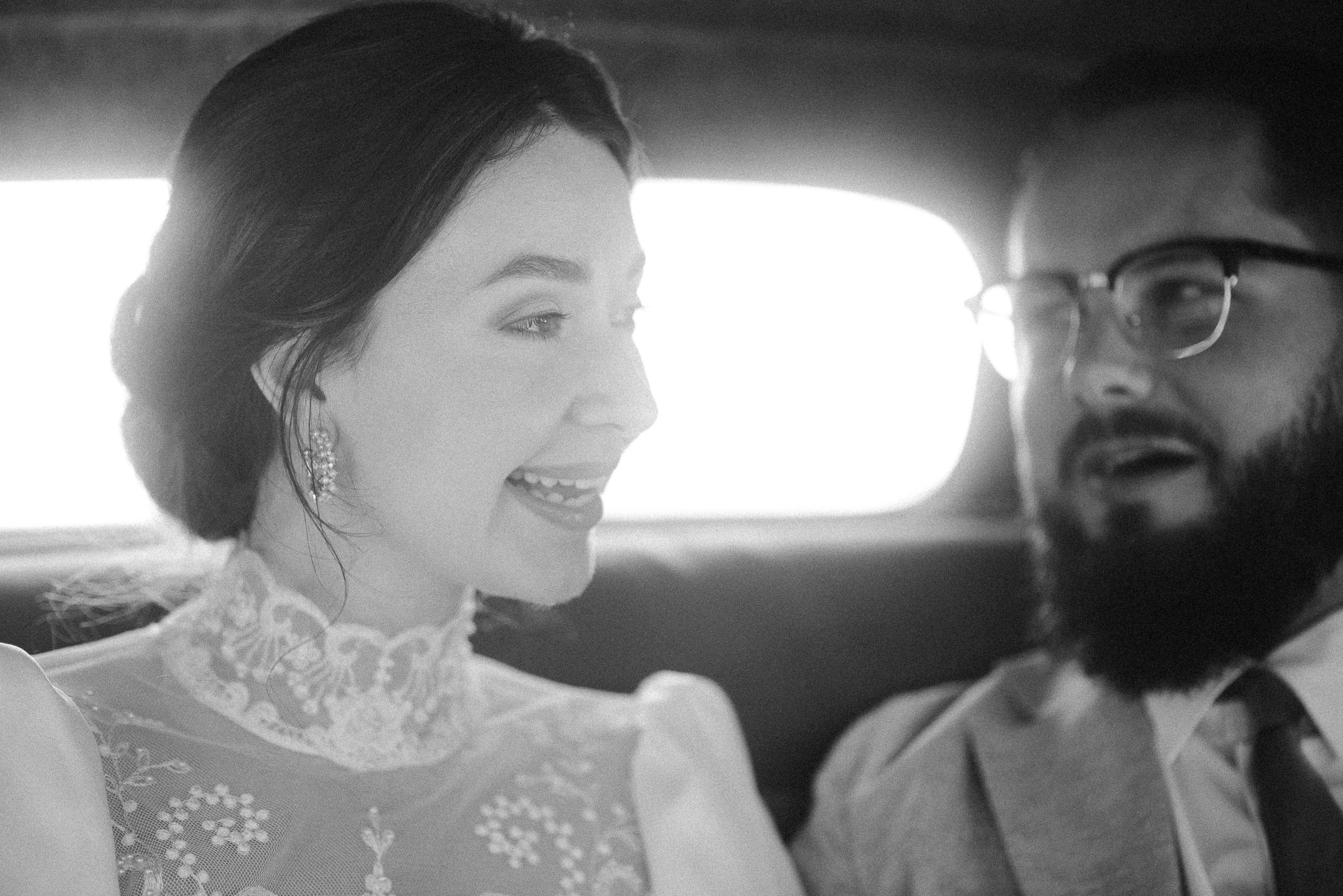 A joyful moment captured between a couple riding in a vintage automobile.