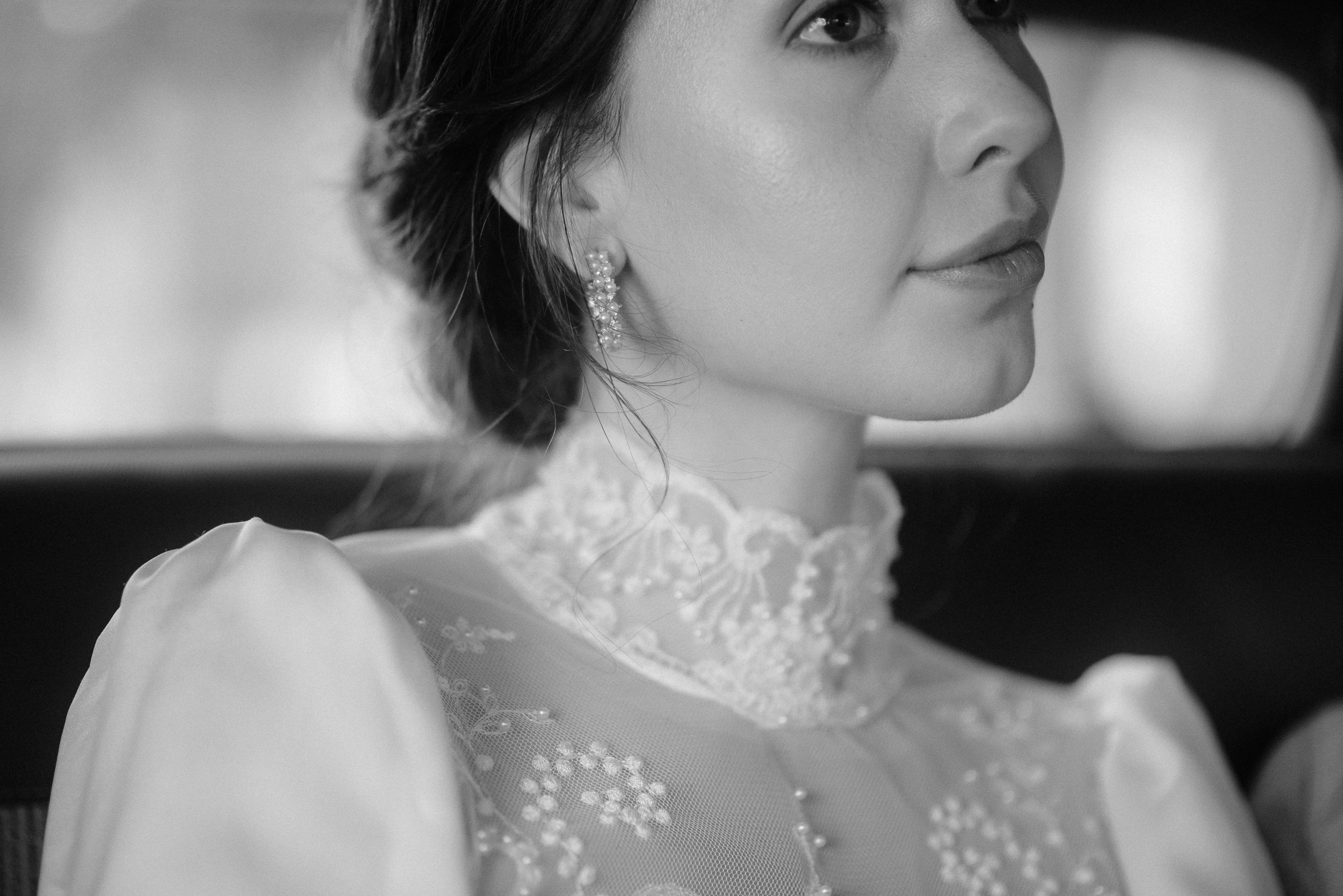 An elegant side profile portrait featuring a high-neck lace wedding dress.