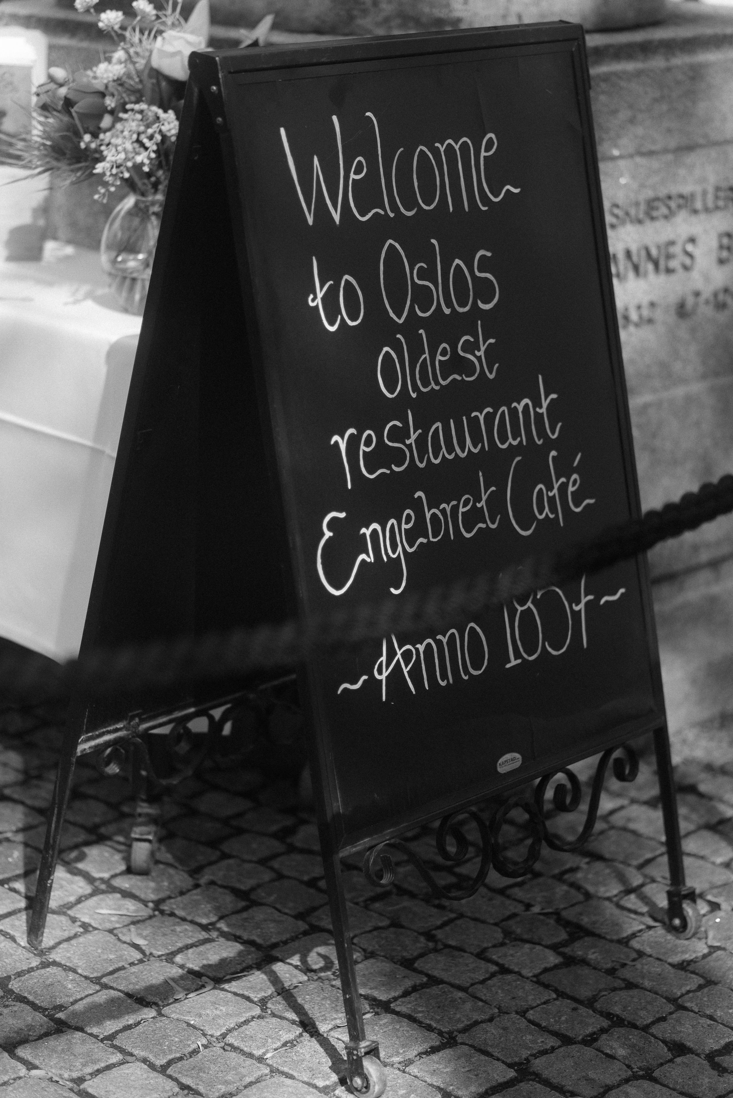 A chalkboard sign welcomes visitors to Oslo's oldest restaurant, Engebret Cafe.