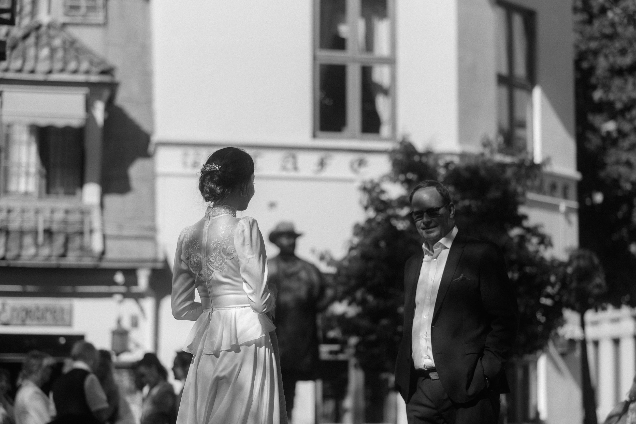 A vintage black and white photo of two people standing outside an elegant building.