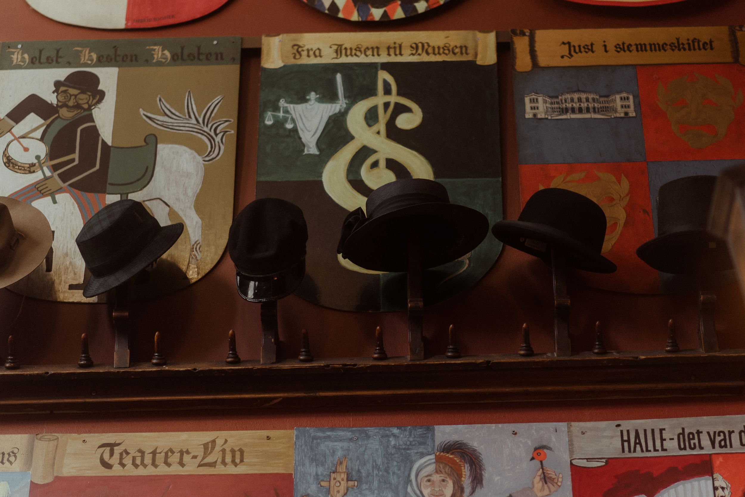 Vintage theater posters with silhouettes displayed on a dark wall.
