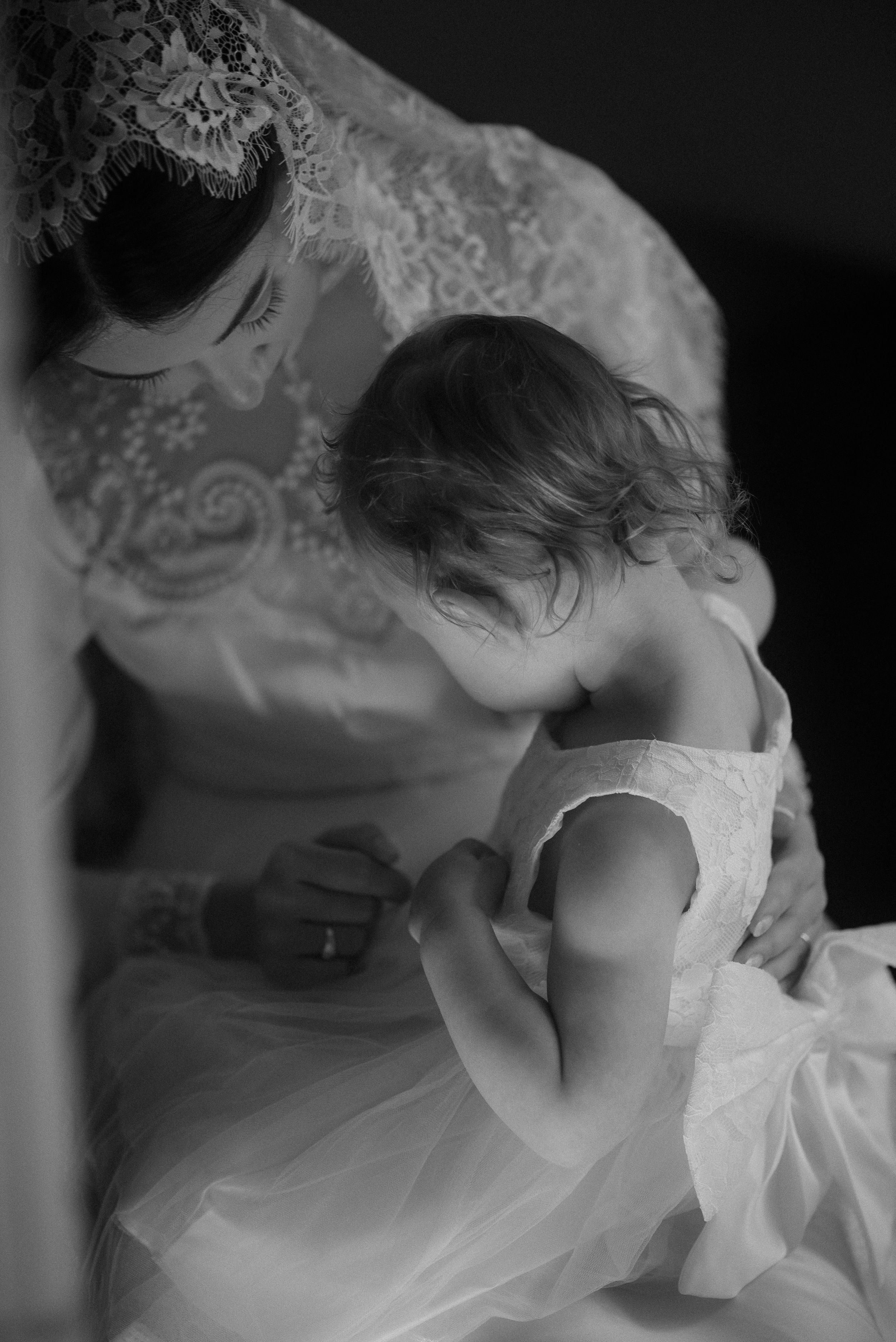 Tender black and white moment with delicate lace and tulle wedding dress details.