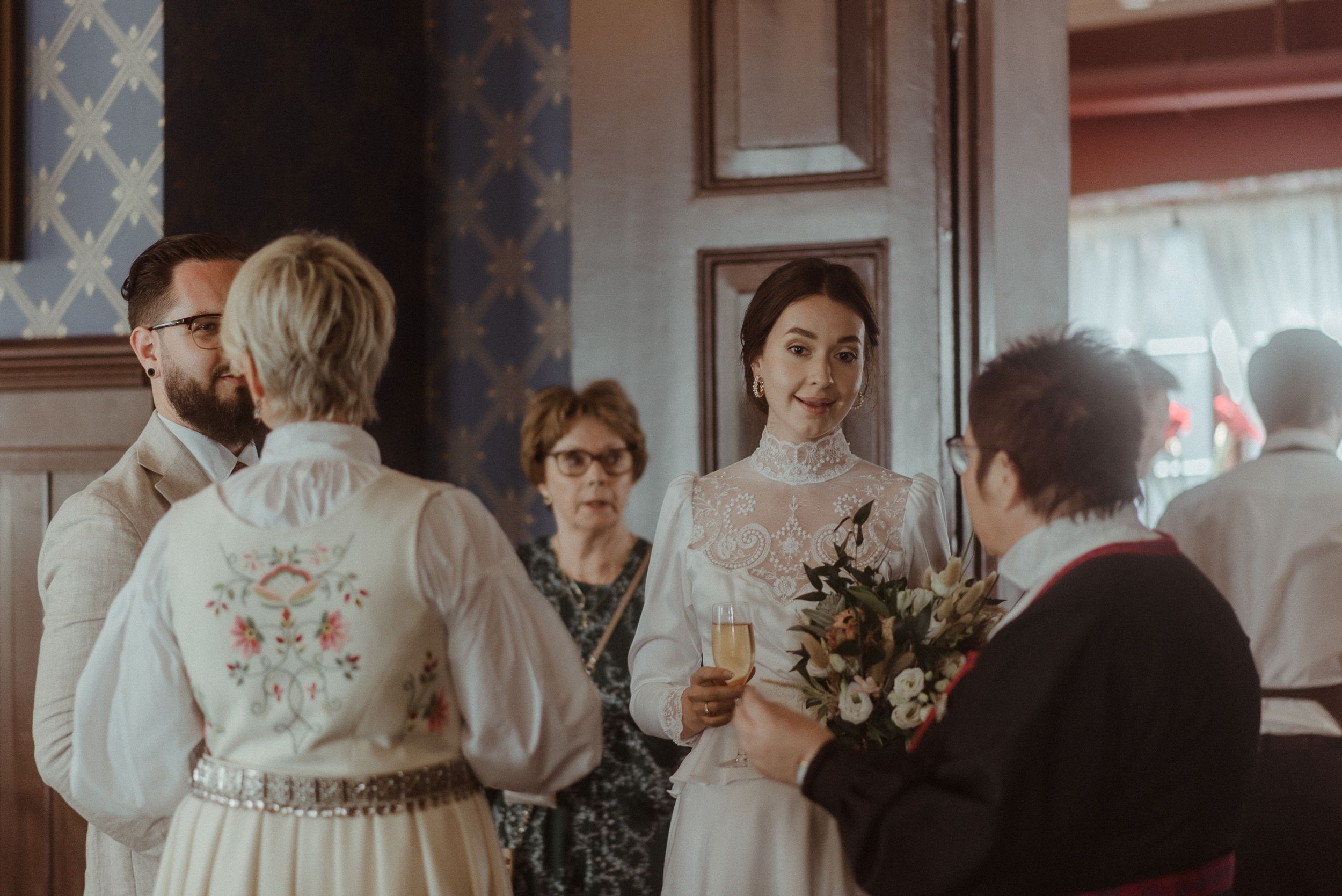 Wedding celebration in an elegant room with vintage wallpaper and traditional decor.