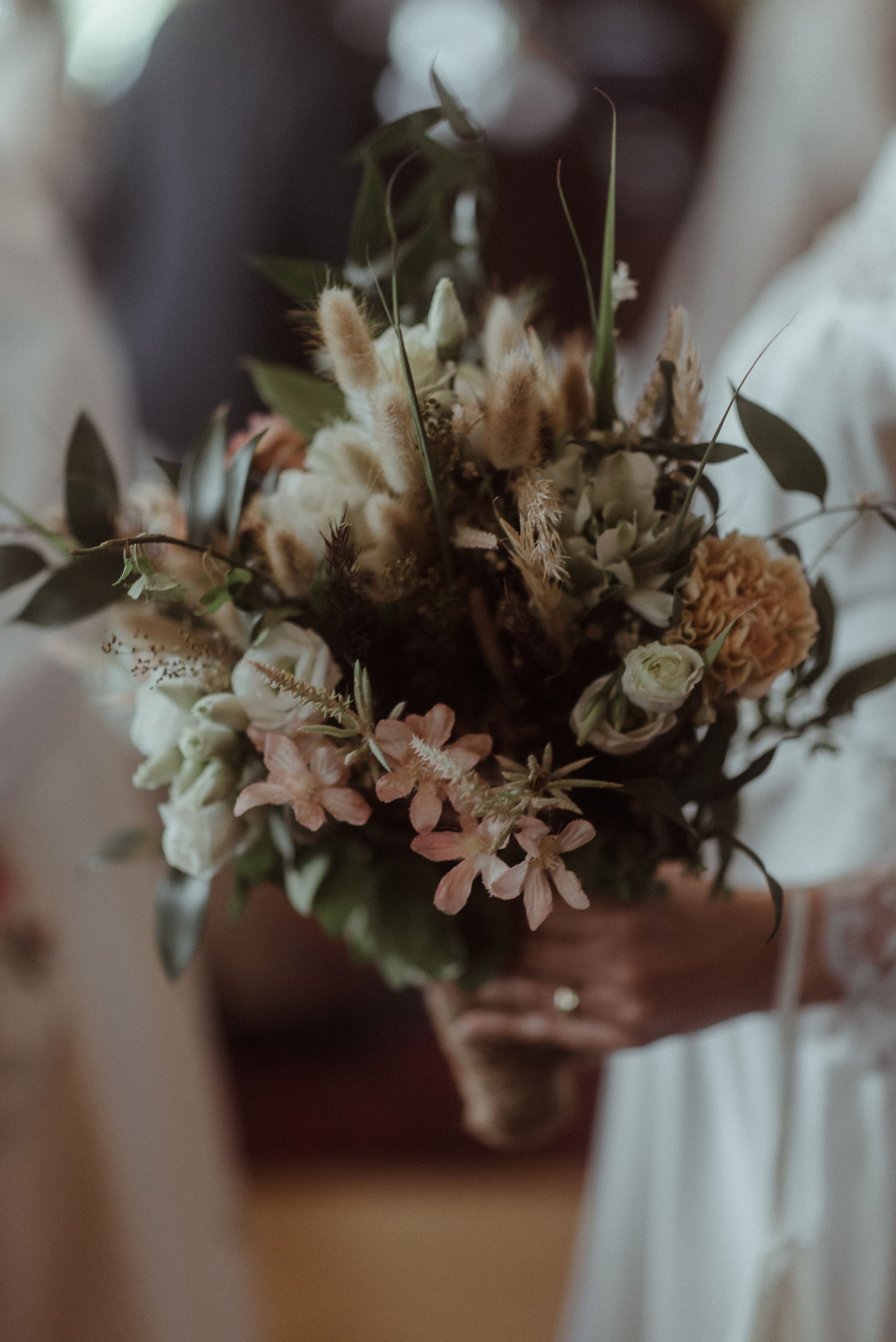 Romantic vintage-style bouquet with dried flowers and delicate pink blooms in muted tones.