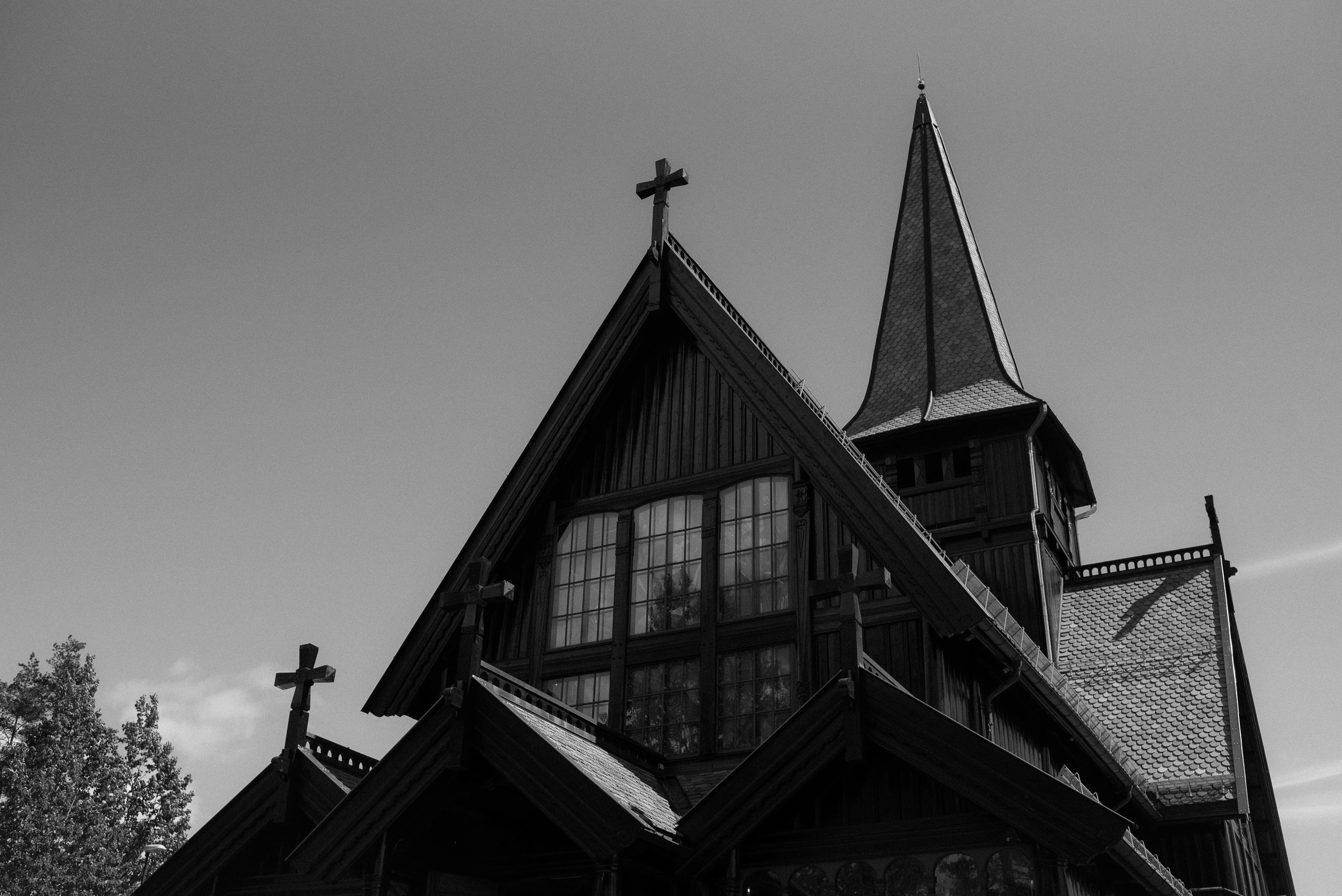Black and white photo of a traditional Nordic church steeple with crosses against a dark sky.