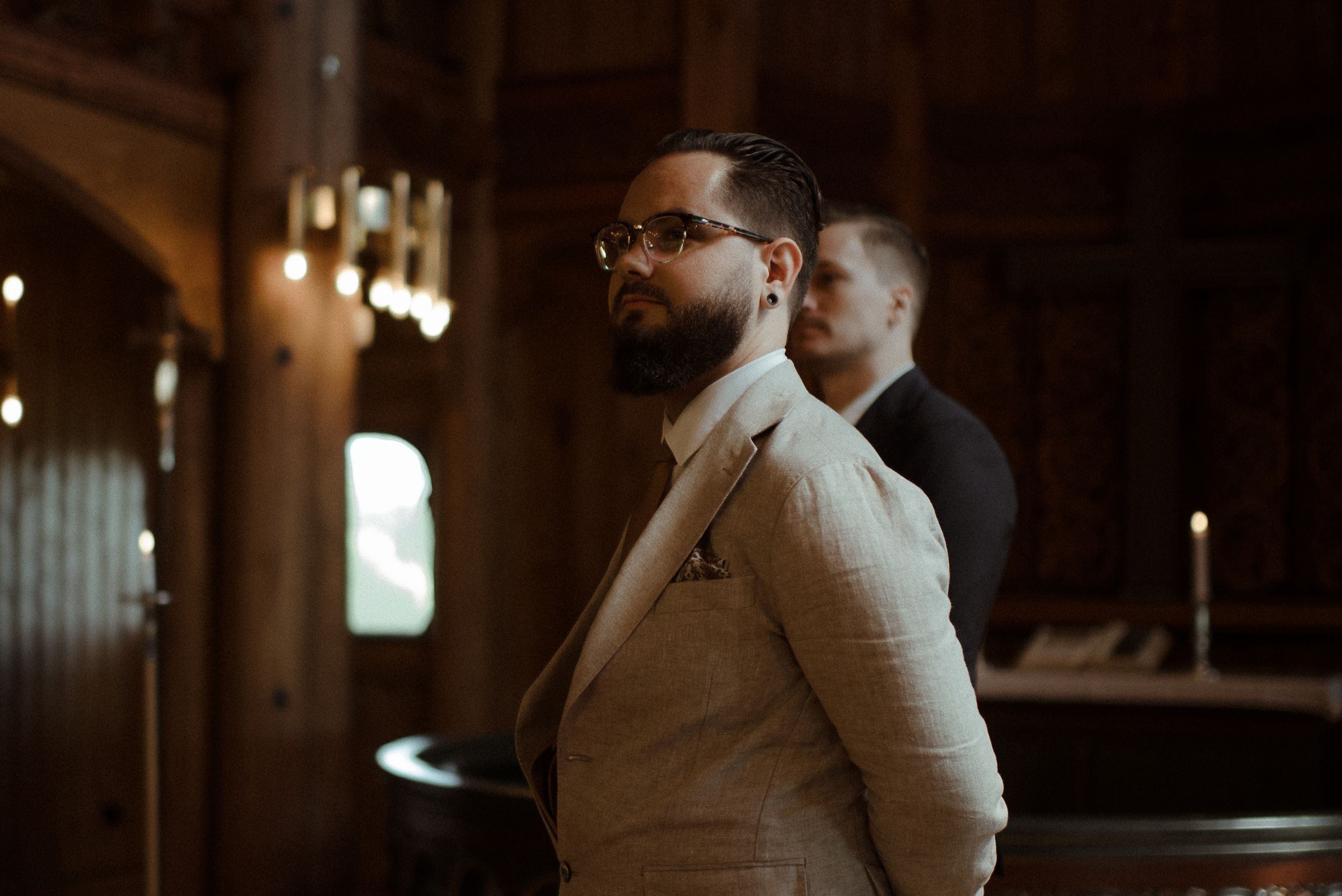 Warm interior lighting illuminates a wooden church during a ceremony.