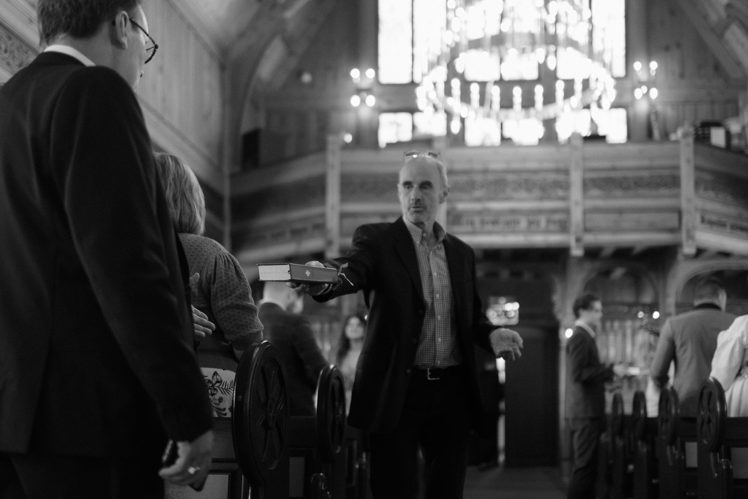 Dark atmospheric scene inside a traditional wooden church during a service.