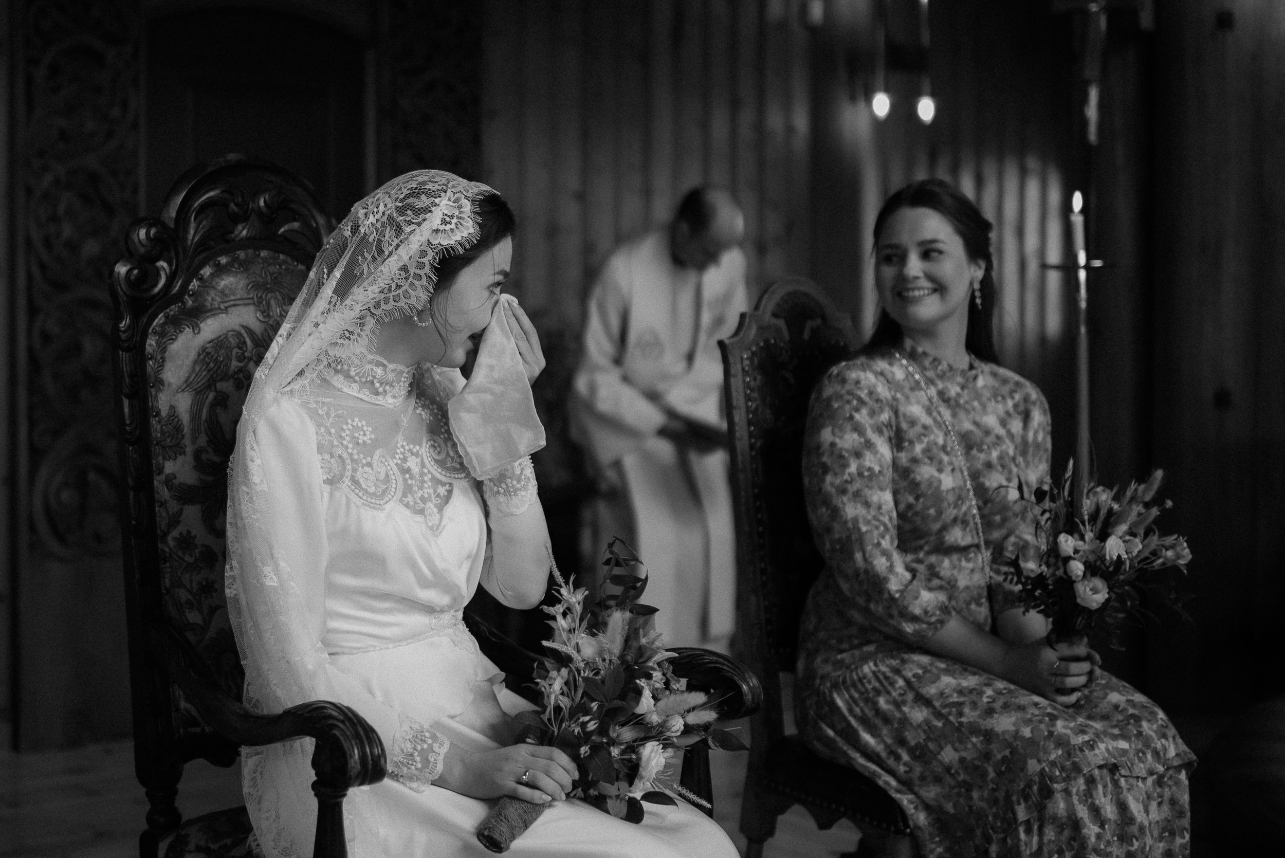 Black and white image of wedding preparations in an ornate interior setting.