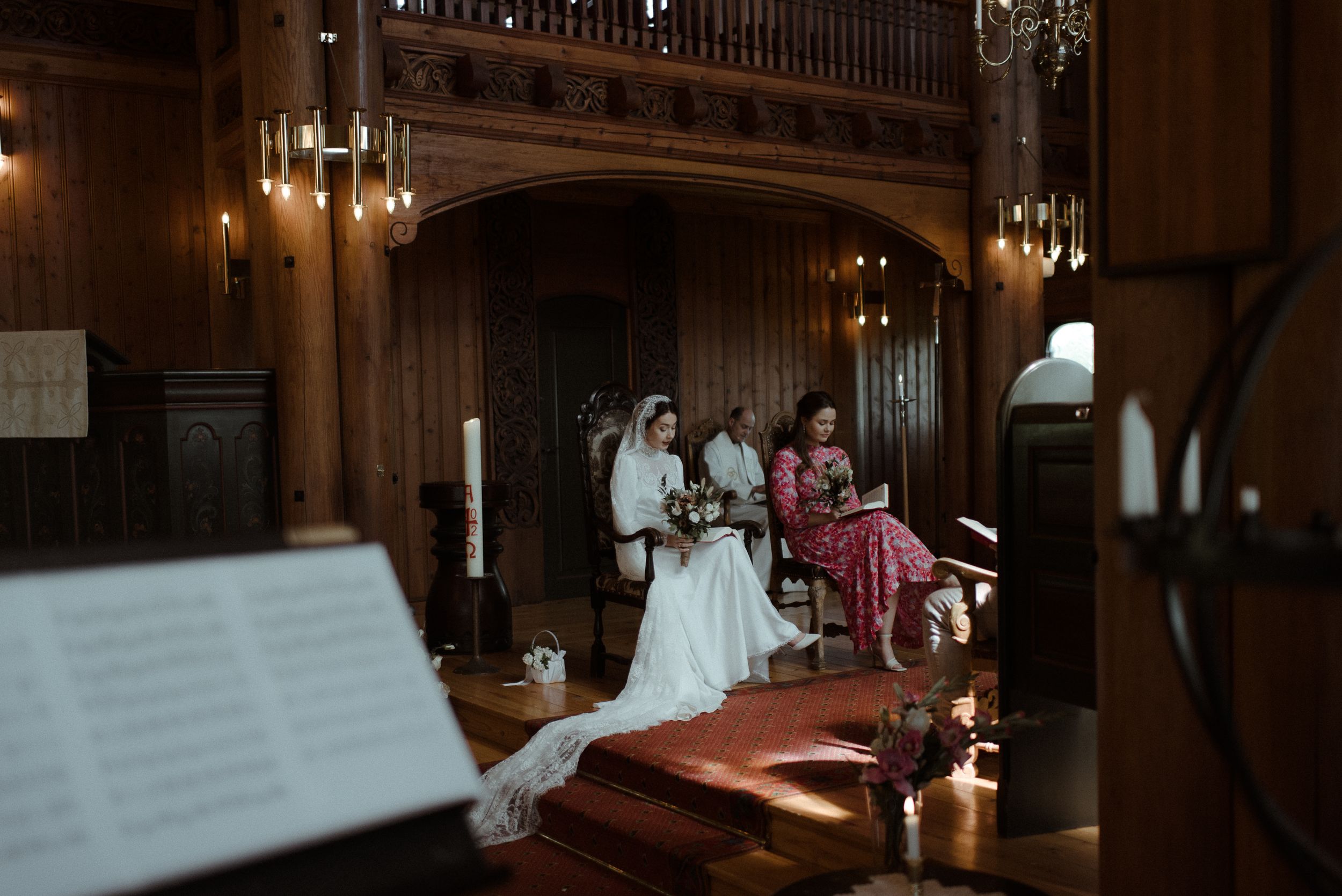 A candid wedding scene inside a historic church with warm lighting and wooden details.