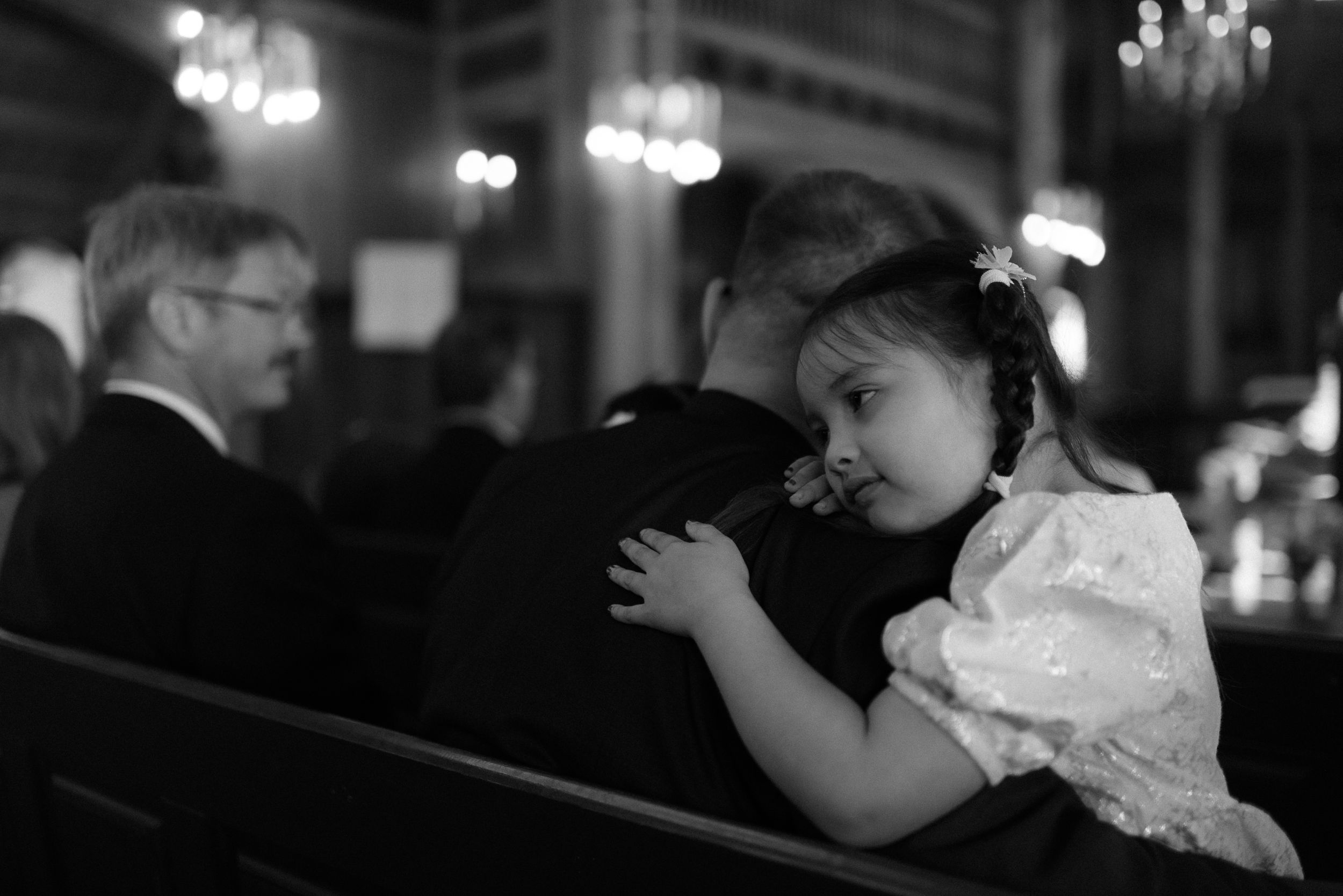 A touching black and white moment during a wedding ceremony in an elegant church setting.