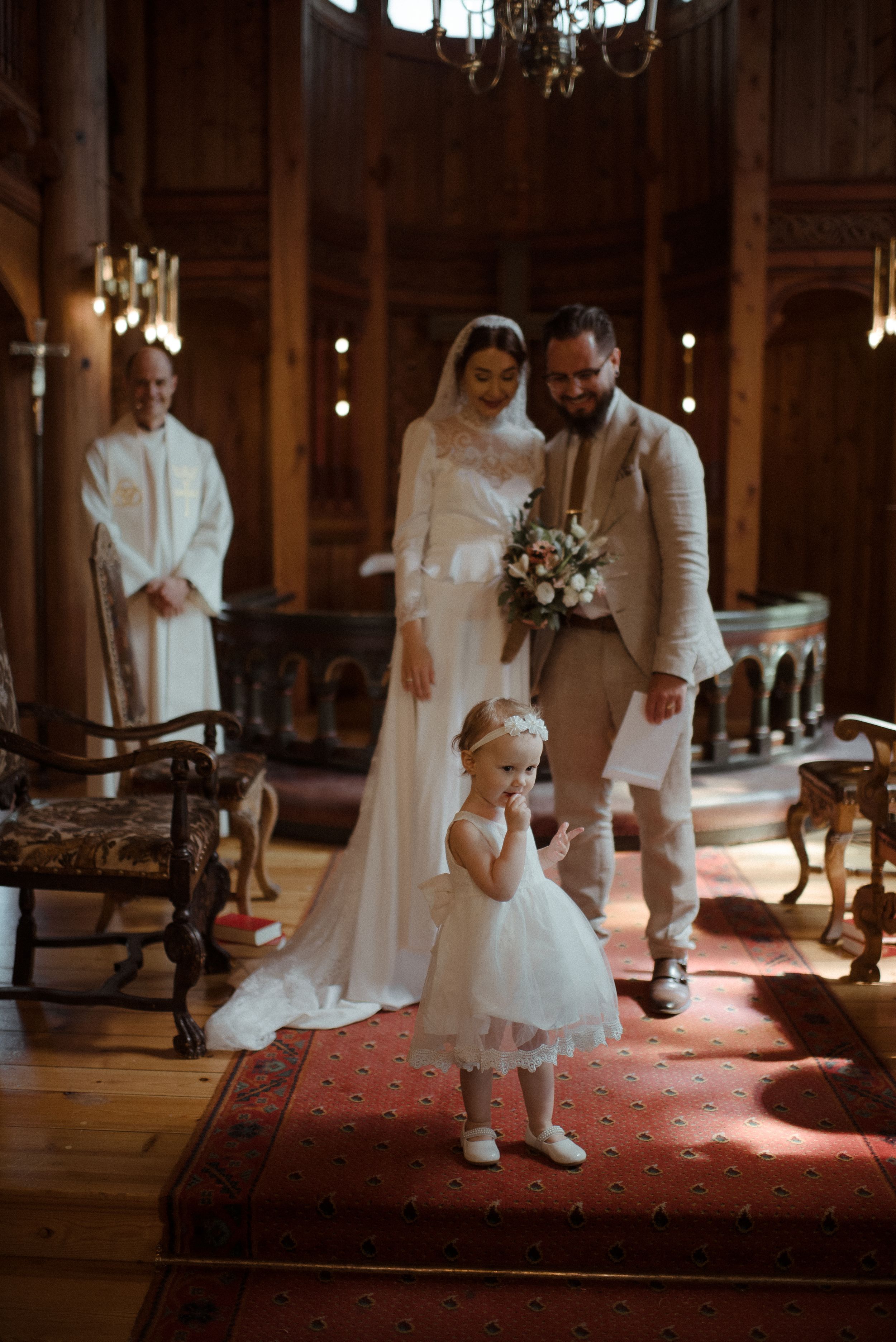 A wedding ceremony in a traditional church with elegant lighting and vintage decor.