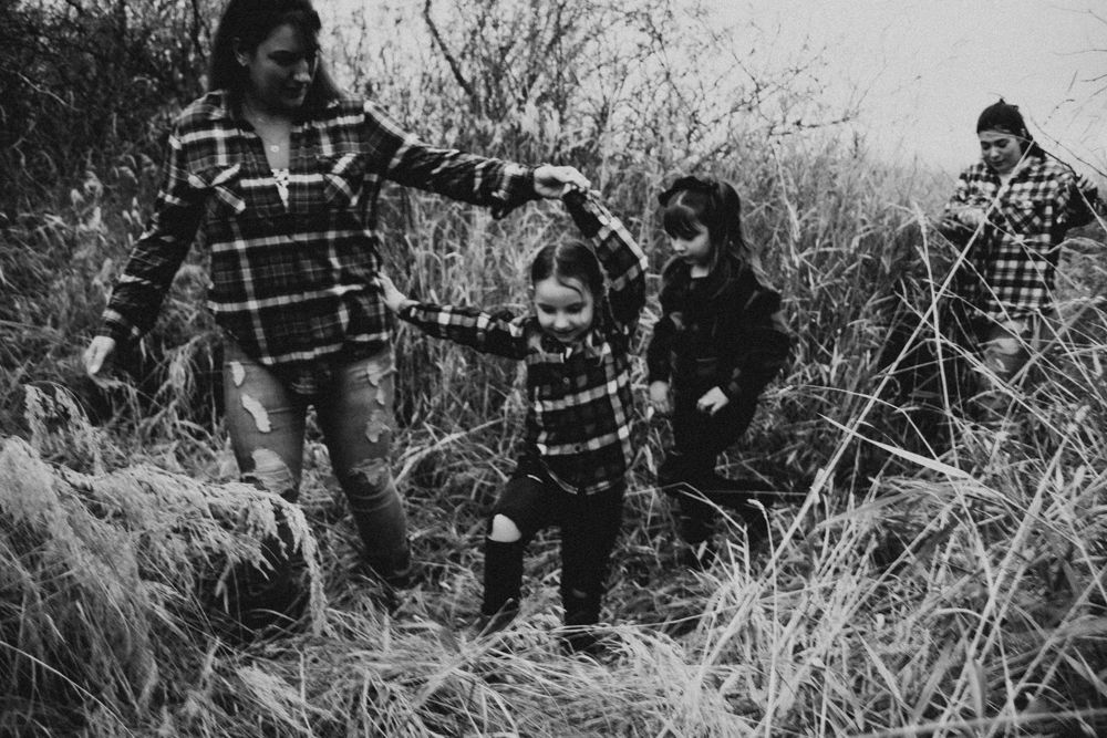 Group walking together through wild grasses in black and white photo.