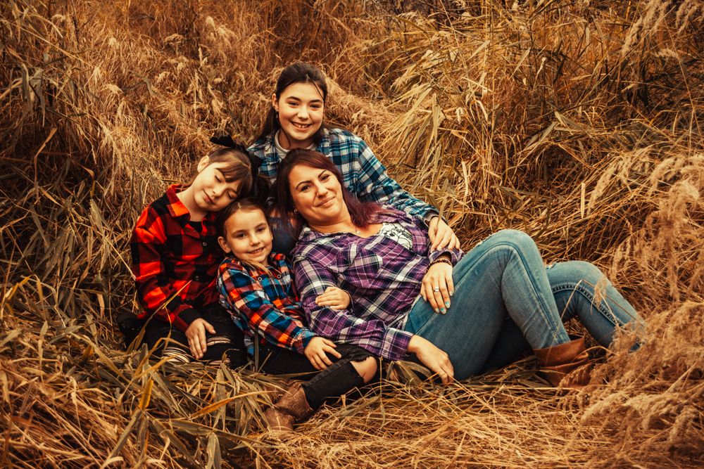 Group lounging together in autumn grass wearing coordinating plaid flannel shirts.