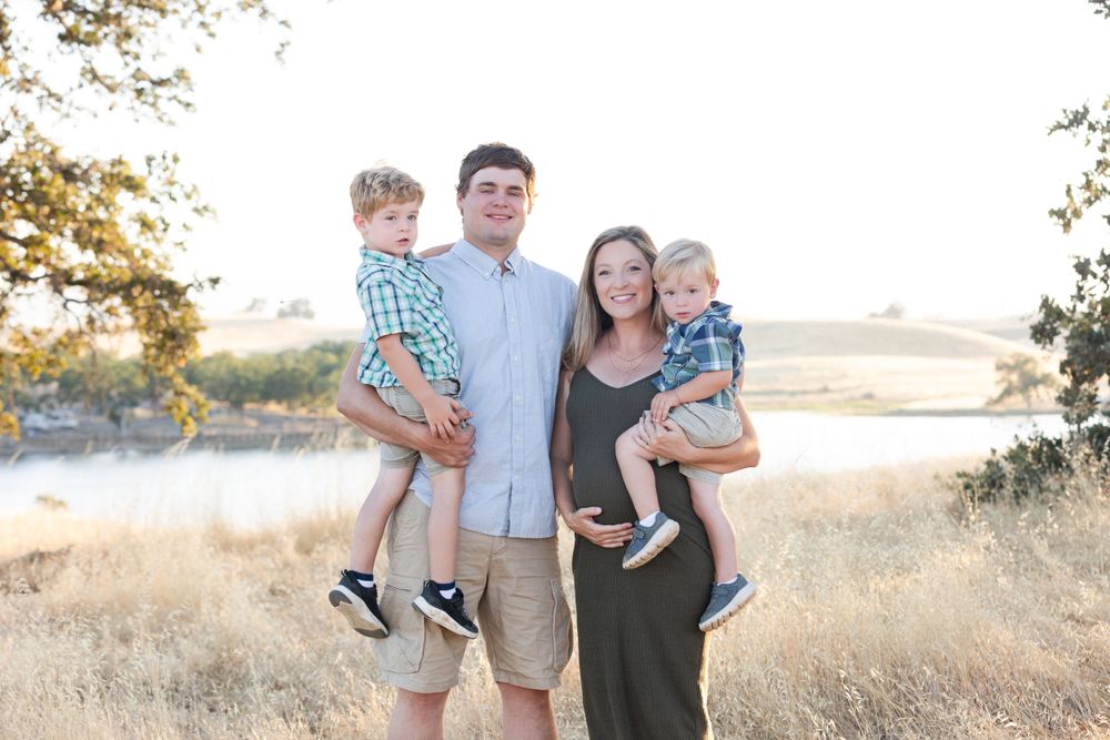Family poses together in golden field during sunset photoshoot at Black Butte Lake.