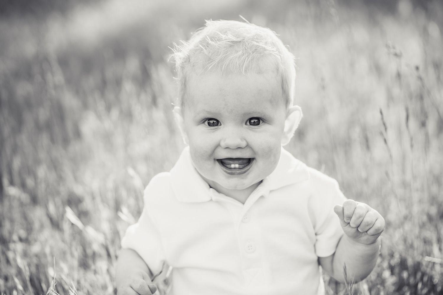 Black and white photo of a smiling 9 month old baby.