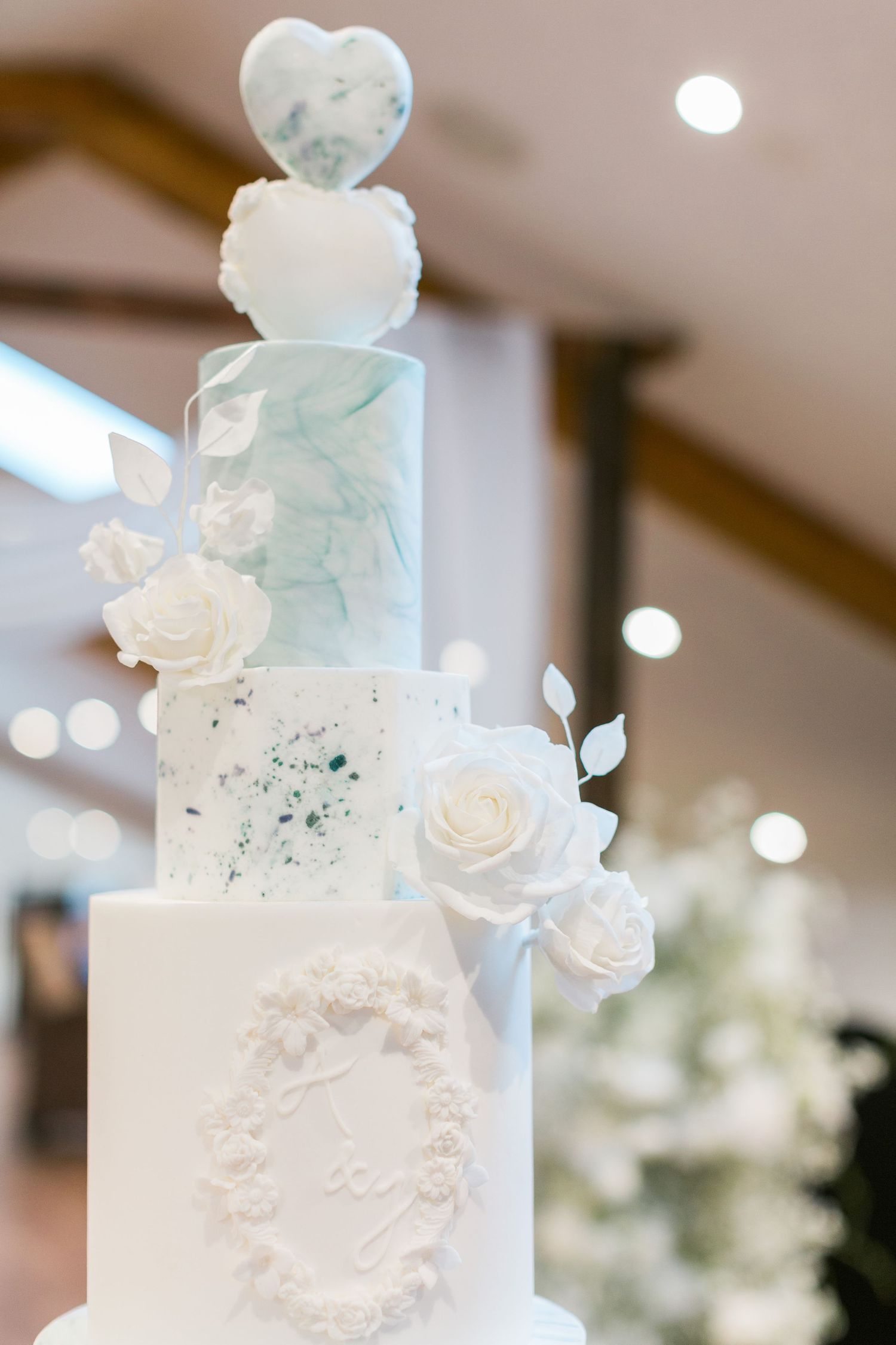 Elegant five-tier white wedding cake decorated with soft blue marble effect, iced roses, ornate piping by Hayley Elizabeth Photography
