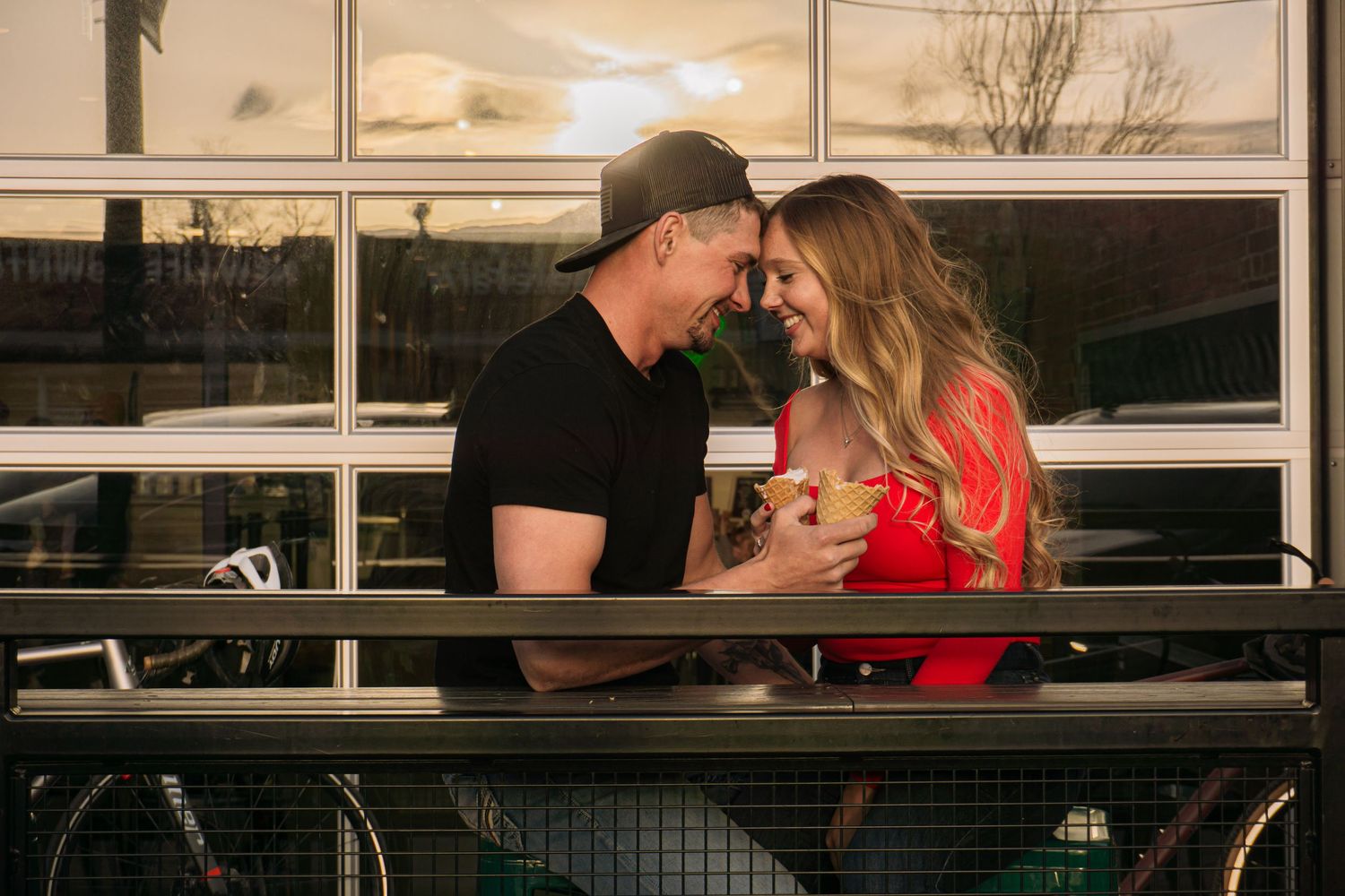 Colorado Springs Engagement Photographer. Couple sitting outside touching foreheads with each other during golden hour.