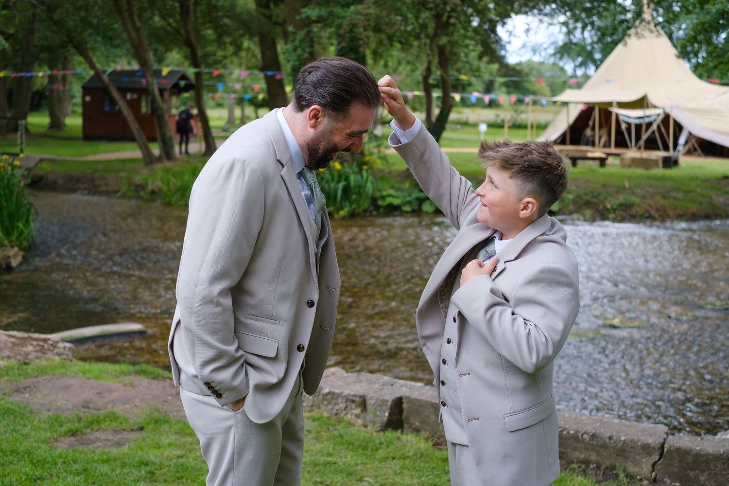 Grooms son and best man is sorting out his dads hair before the wedding