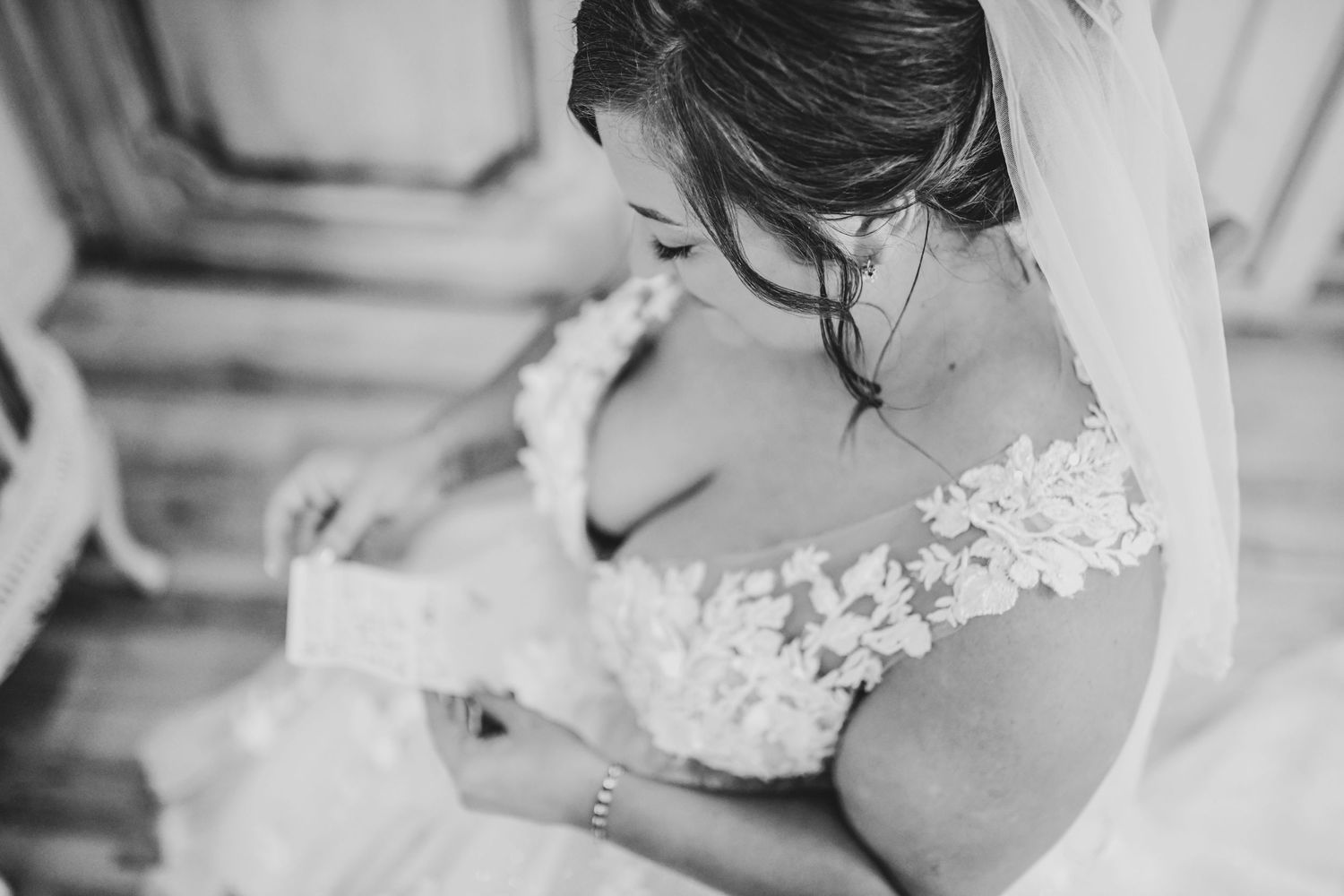 Bride smiling softly while reading a heartfelt letter from her groom