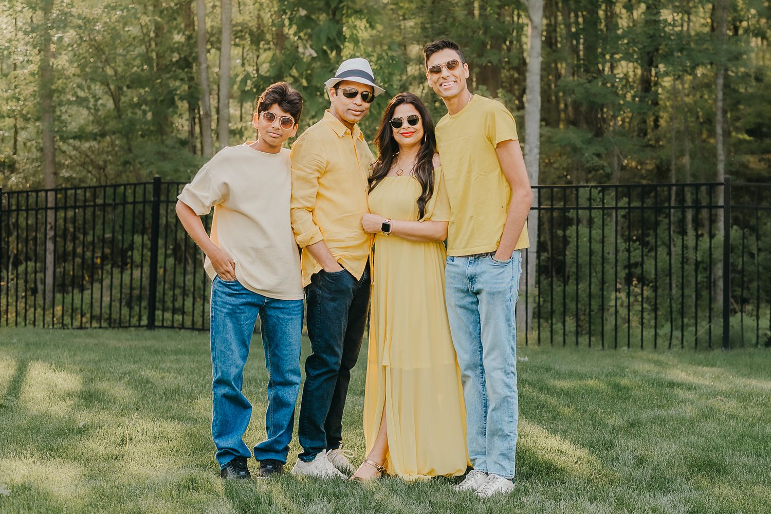 A group poses outdoors in casual wear including yellow and cream outfits in their backyard