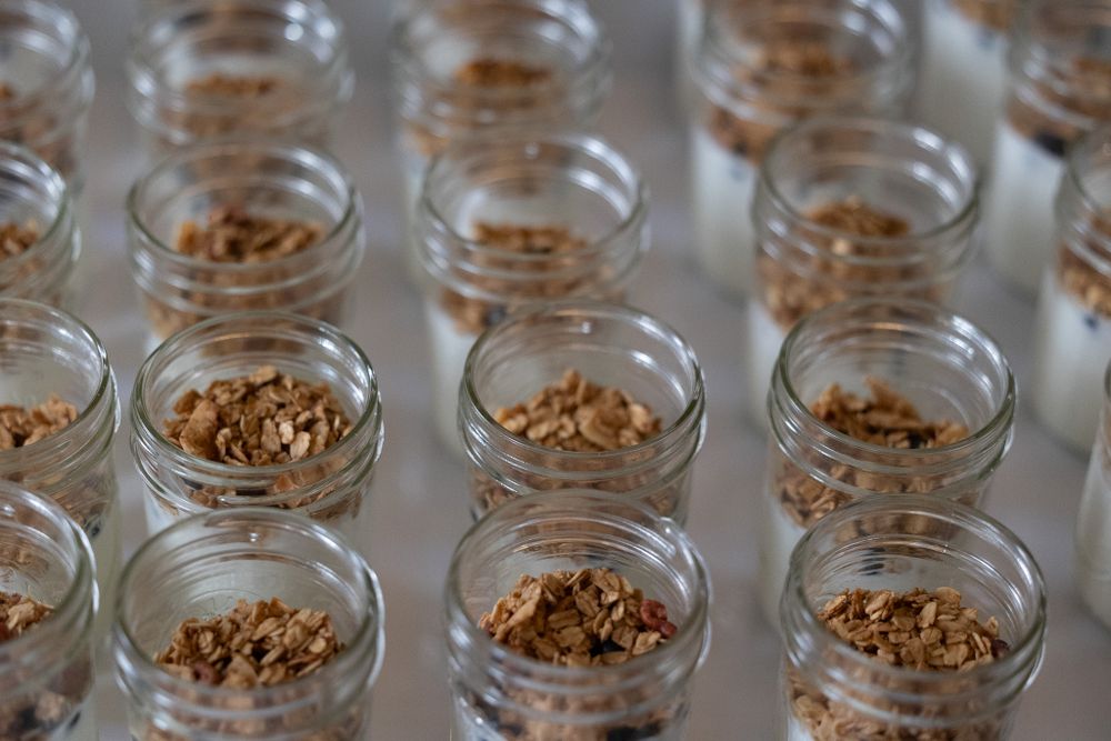 Rows of small glass jars filled with granola or nuts arranged systematically.