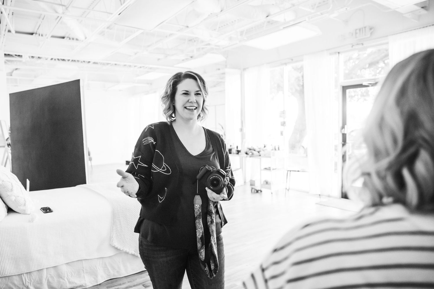Person speaking and gesturing during presentation in bright indoor space.