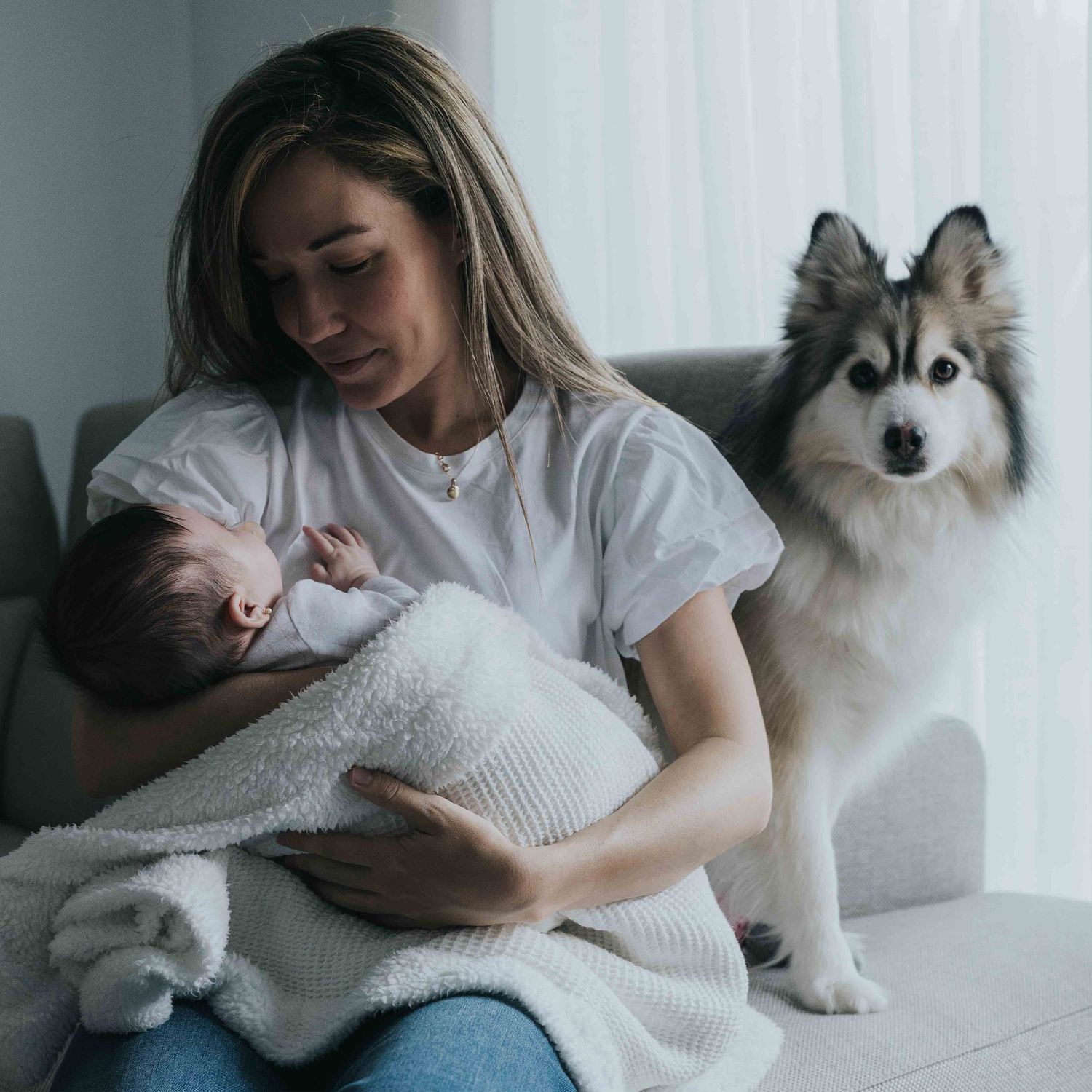fotografo de perros y mascotas, una madre mira a su bebé con su mascota detrás