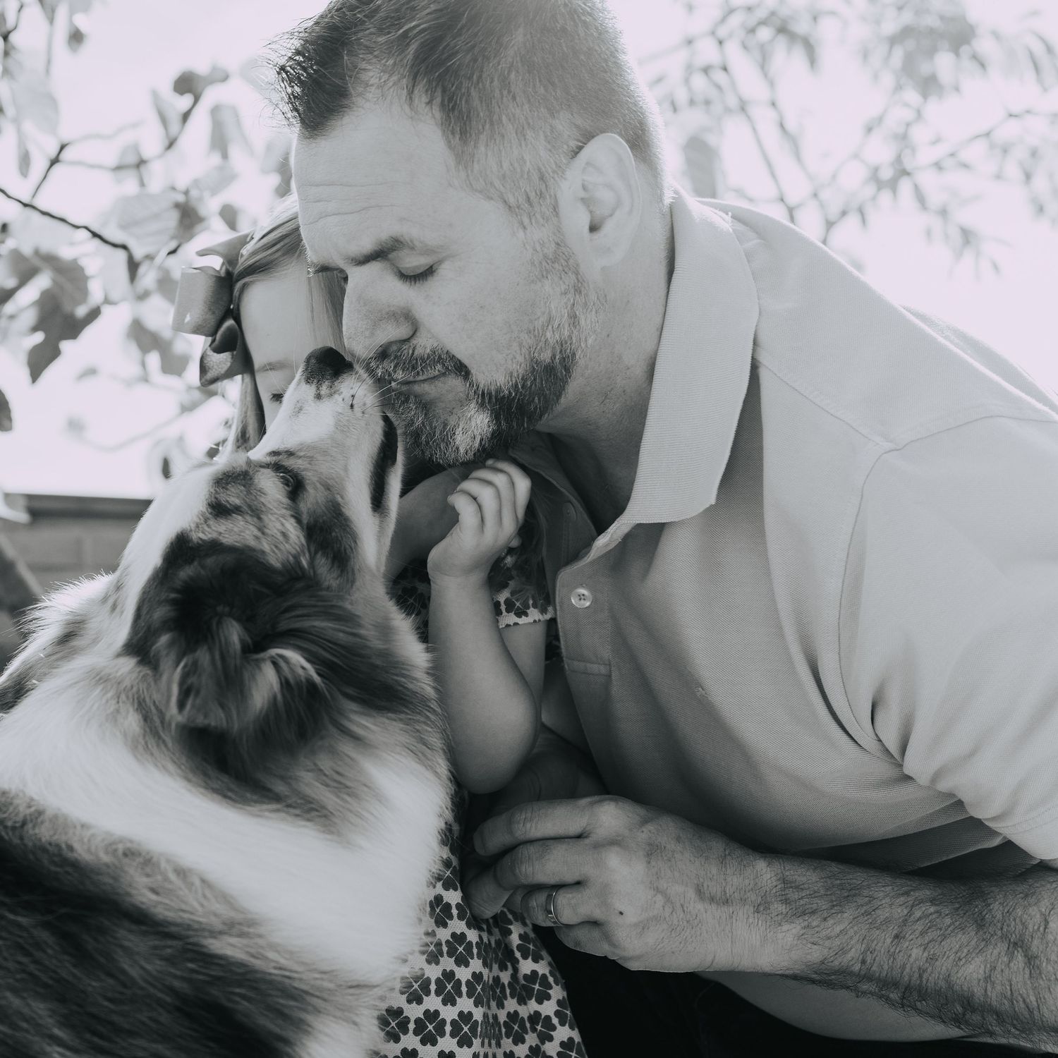 fotos de un beso entre un padre de familia con su hija y su perro