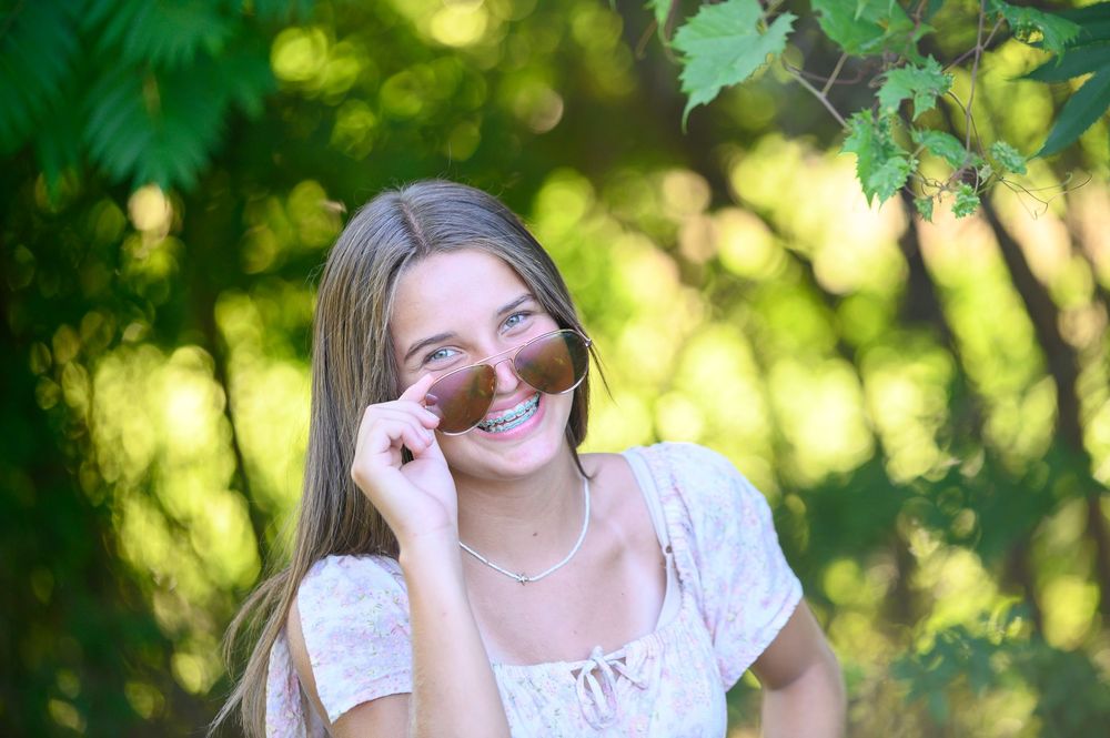 Seven images showing a person laughing and enjoying a sunny summer day outdoors in a garden setting.