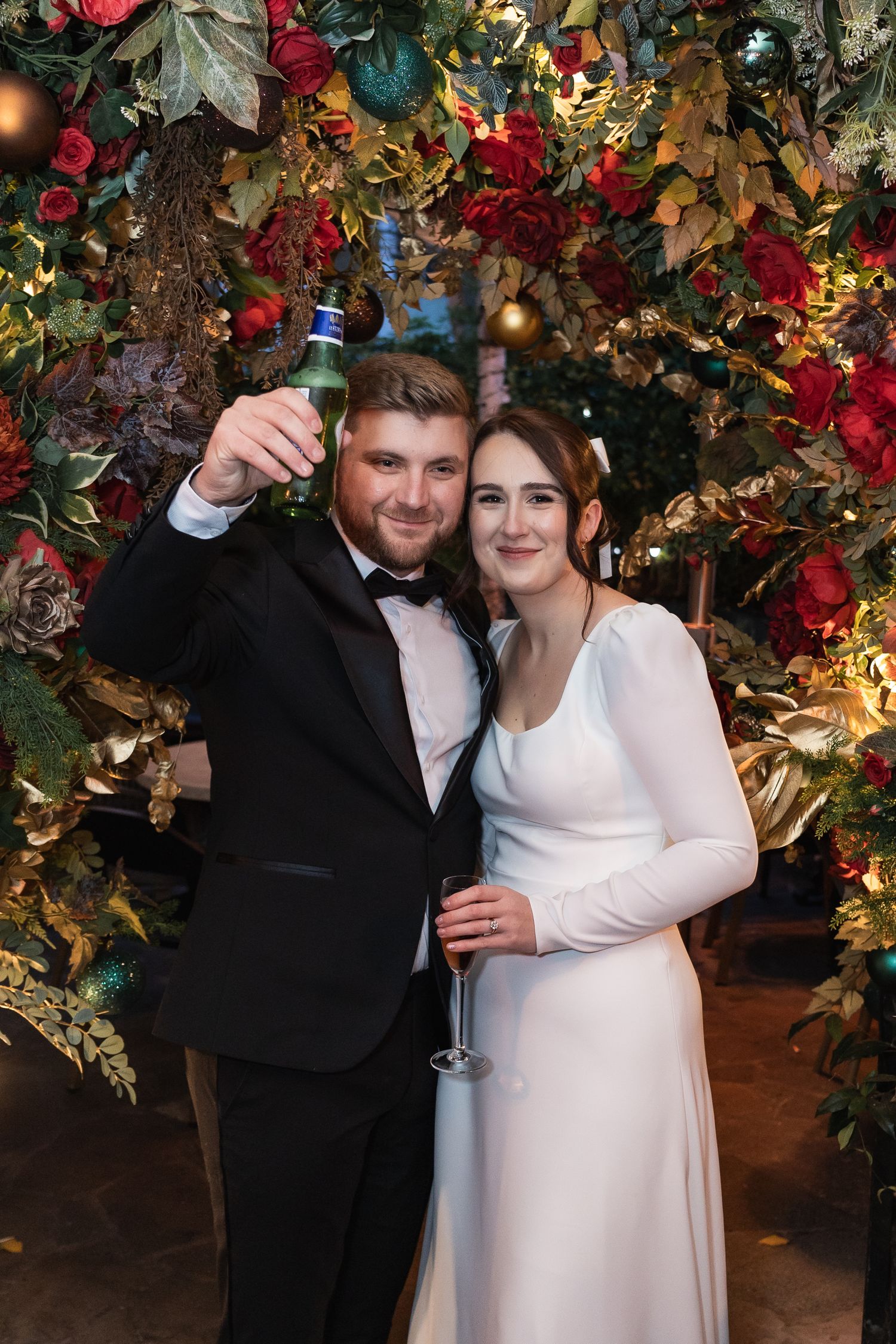 Couple portrait at The Phene. The groom is lifting a glass of champagne to toast.