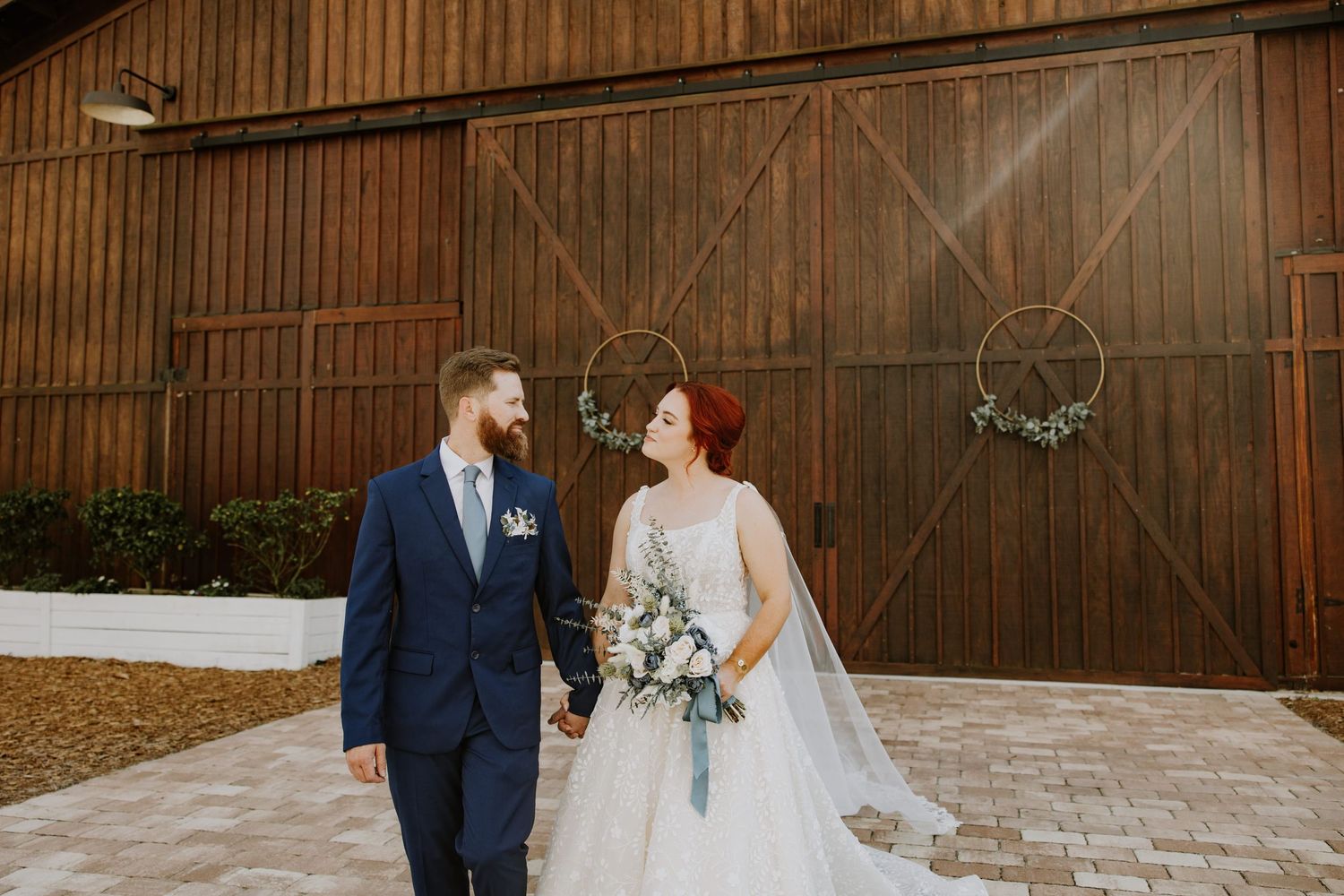 Bride & groom wedding photos at Ever After Farms Stockyard Barn in Okeechobee, FL captured by Lindsay McDow Photography. Top Knot Artistry.