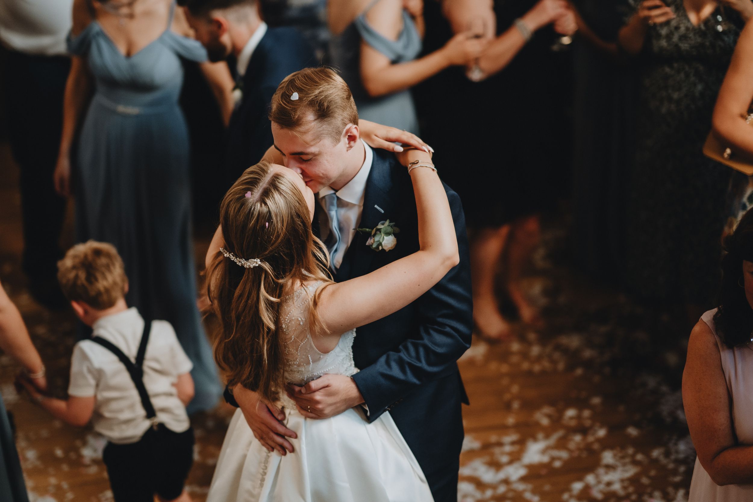 A tender moment shared between a couple during their first dance at a wedding reception while guests look on.