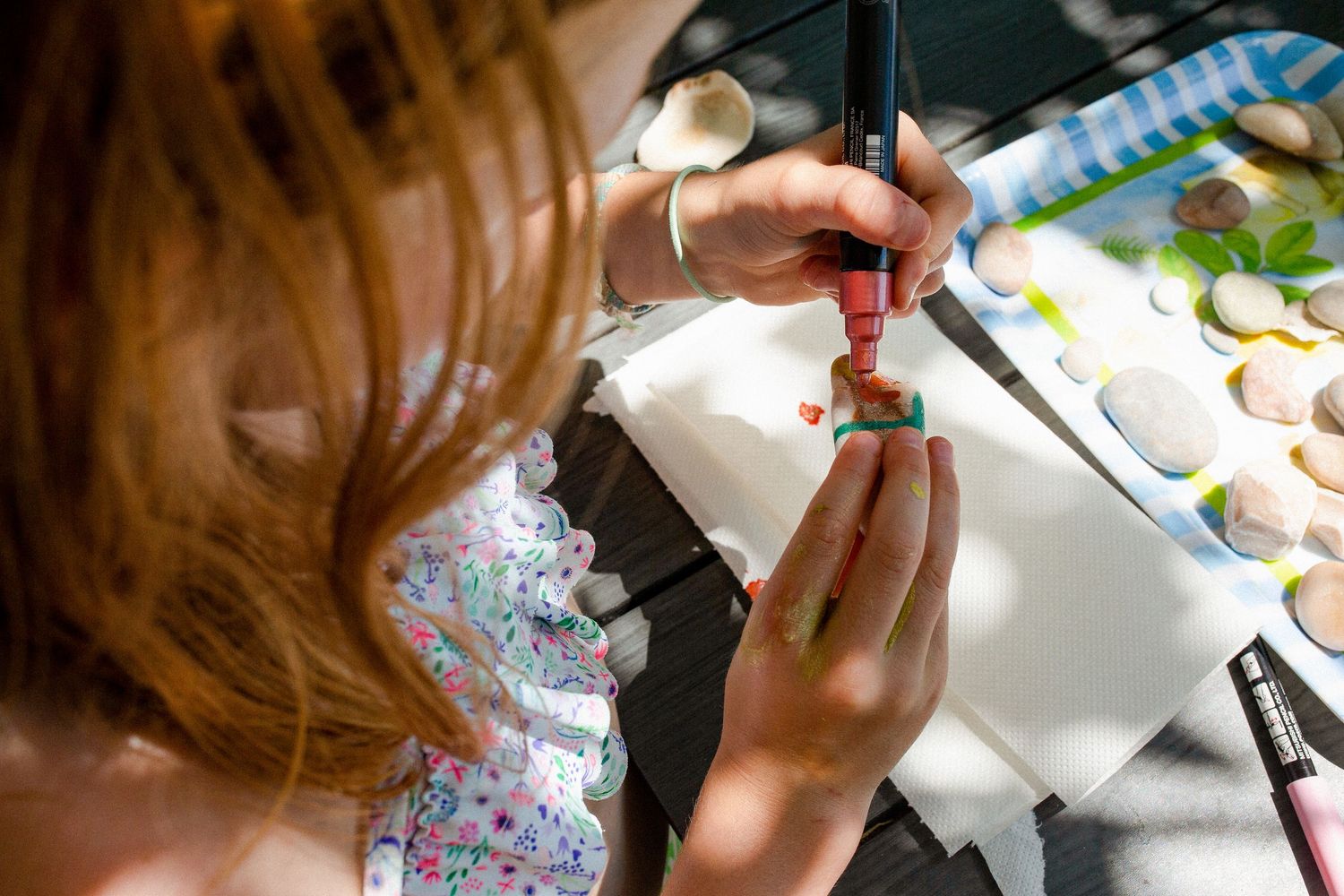 Close up of girl decorating pebble