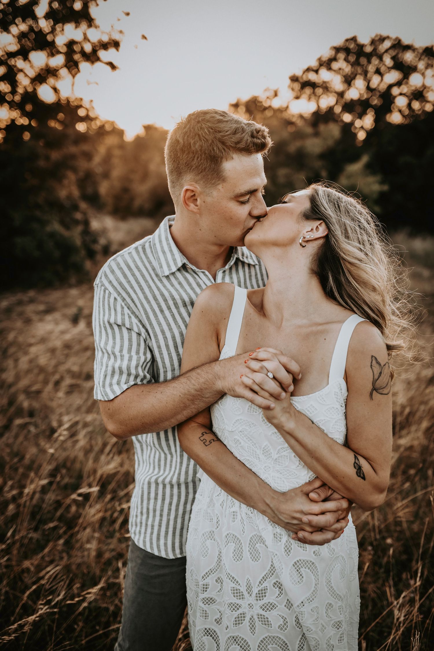 Engaged couple in love, surrounded by golden grass and sun-kissed skies
