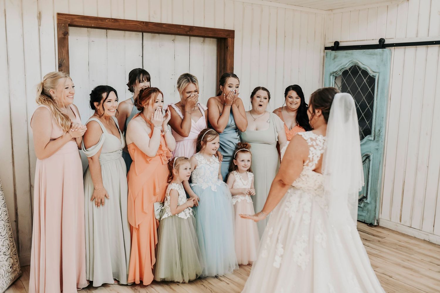 Bride’s emotional first look with bridal party in pastel gowns