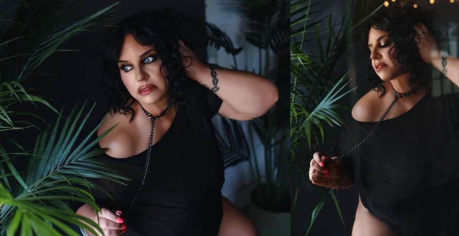 Dramatic portrait in dark lighting with tropical palm leaves framing the subject wearing a black outfit.
