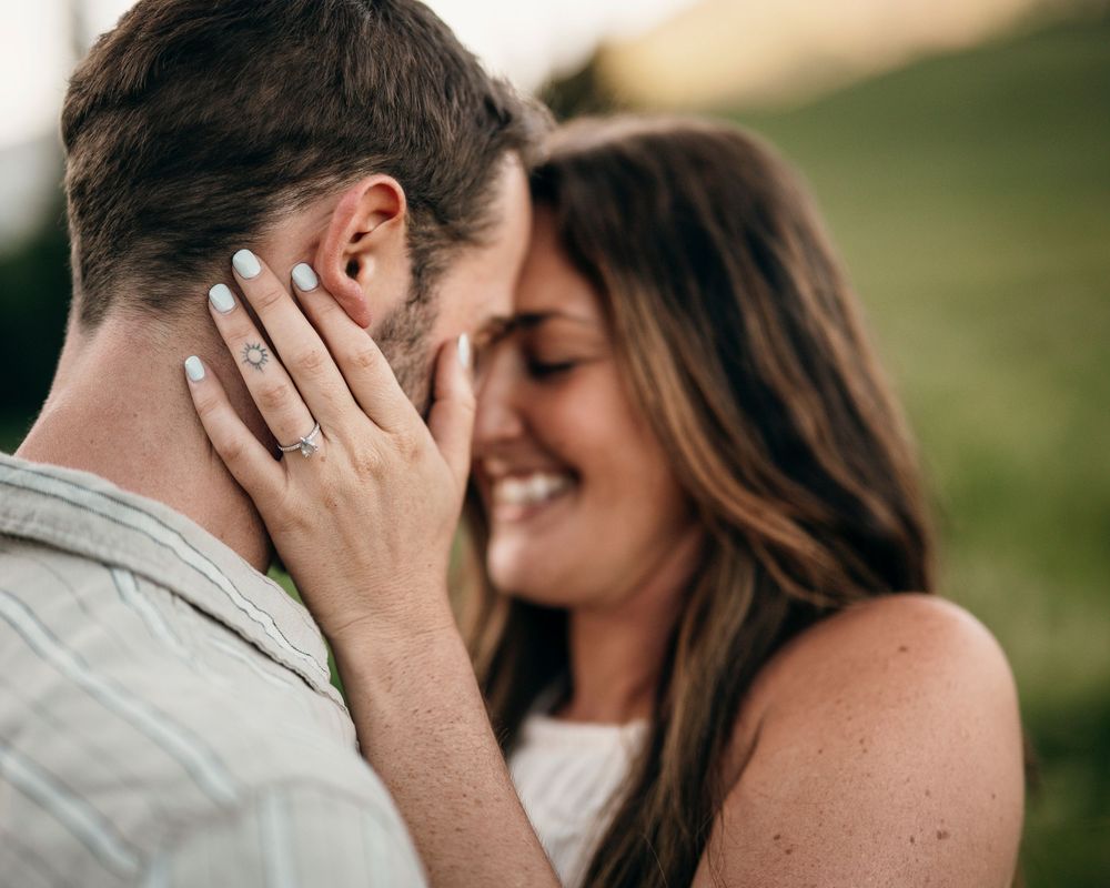 Intimate moment captured between couple in outdoor mountain setting.