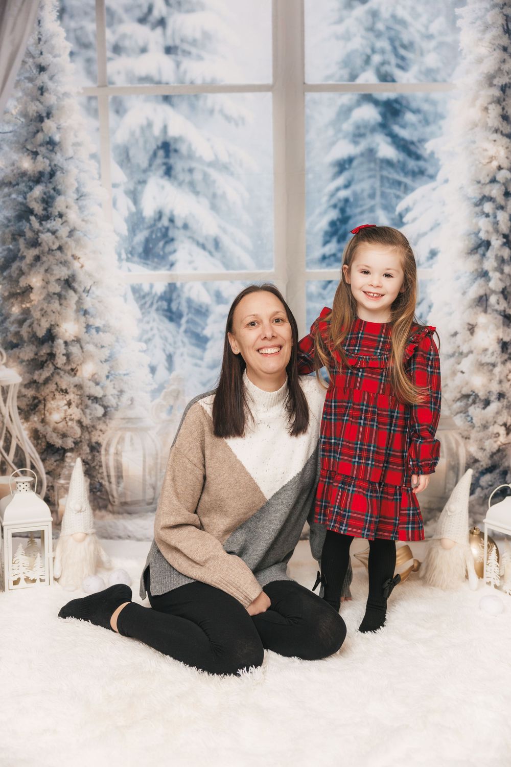A winter photo set with snow-covered trees and festive red plaid accents in a bright white studio setting.