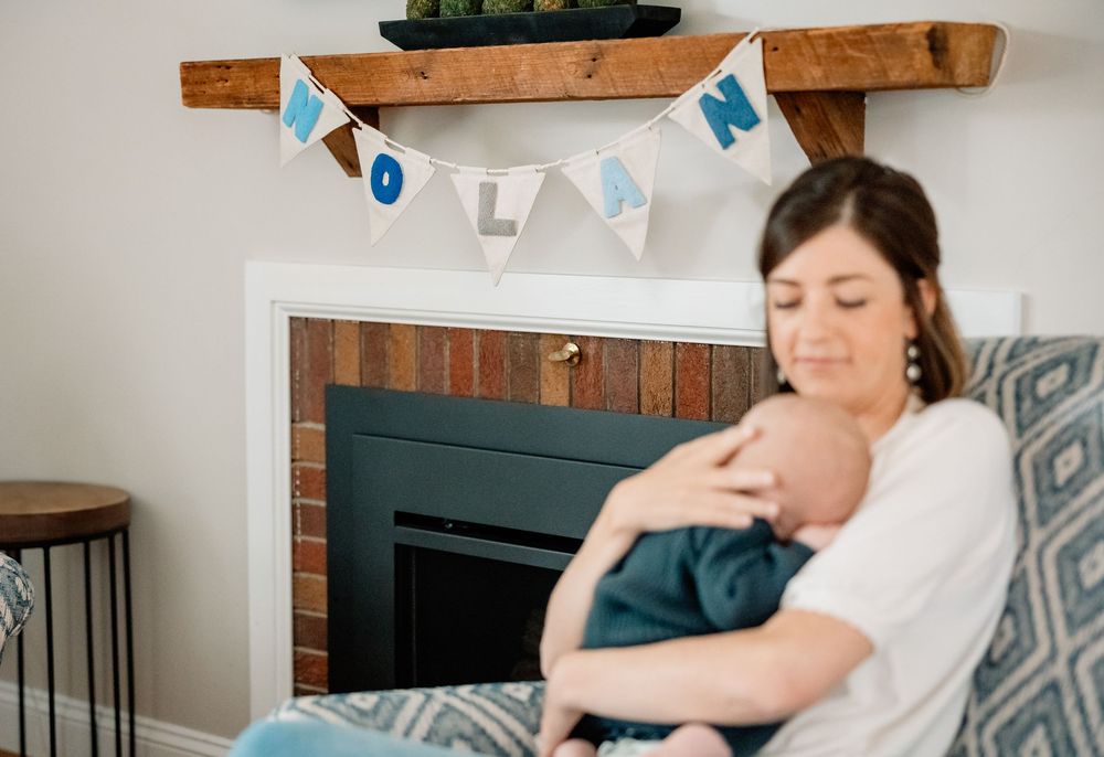 A peaceful moment of holding a newborn baby beneath decorative bunting.