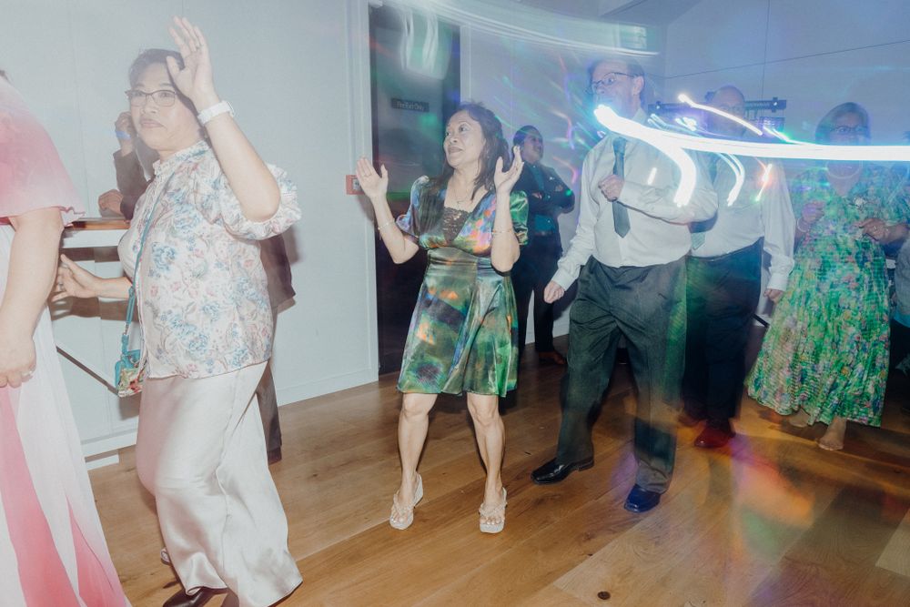 People dancing at a party with motion blur effects on a wooden dance floor captured by Apertured Media Auckland Wedding Photographer.