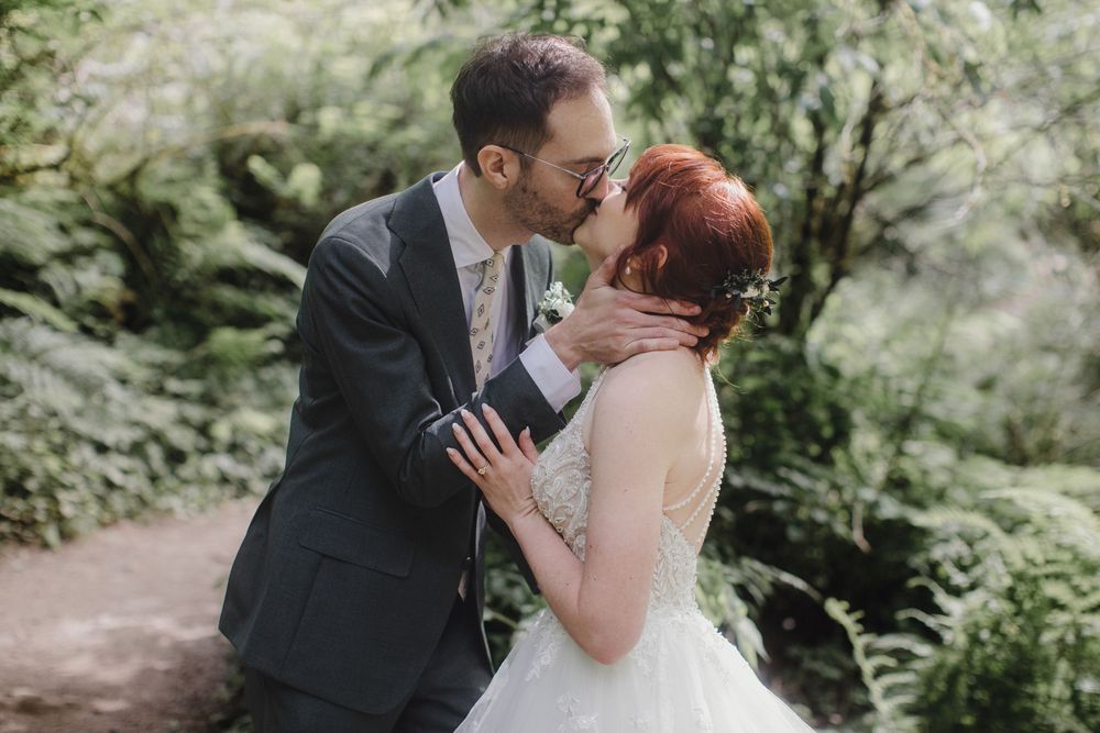 An intimate wedding moment shared between newlyweds in a dreamy forest setting.